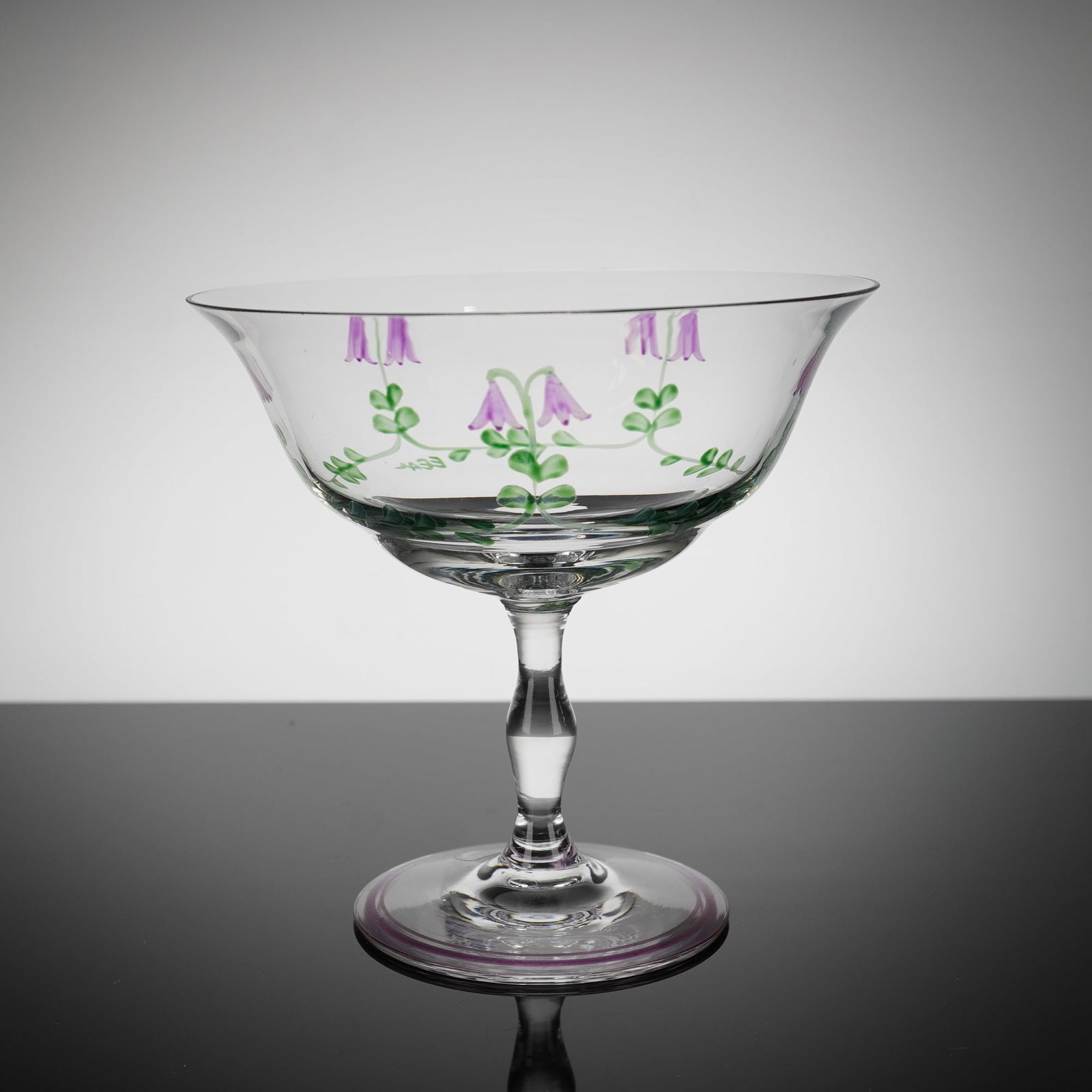 Orrefors Linnea Crystal Dessert Bowl by Eva Englund: A single stemmed crystal dessert bowl, in the 'Linnea' patern, designed by Eva Englund for Orrefors, Sweden. The clear glass features hand-painted decoration depicting stylized purple bellfi?owers on