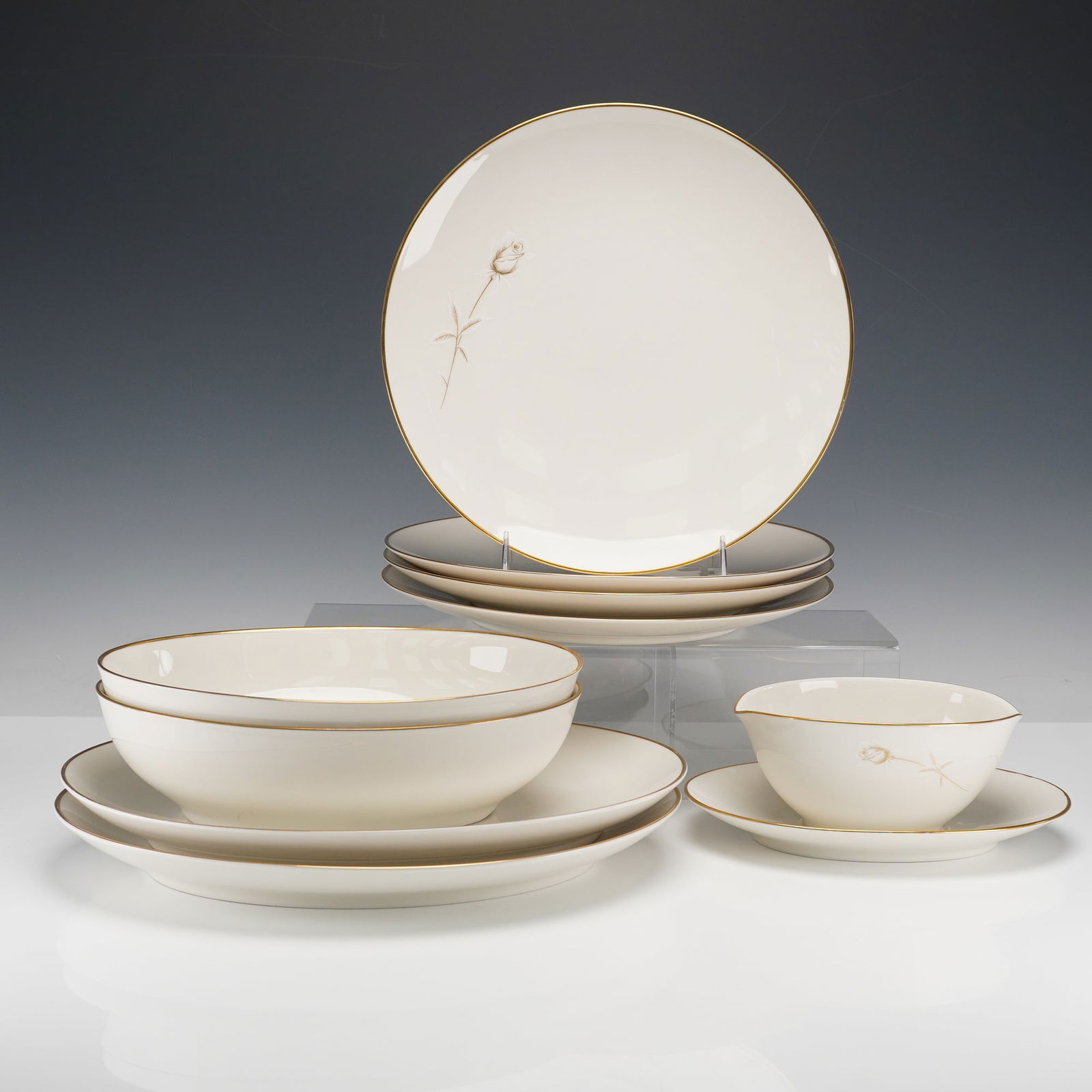 9pc Noritake Ivory-China Tableware for Four, Nora: Collection includes four dinner plates, two serving plates, two serving bowls, and one gravy boat attached to the undertray. Each piece is crafted in fine bone china adorned with a delicate single