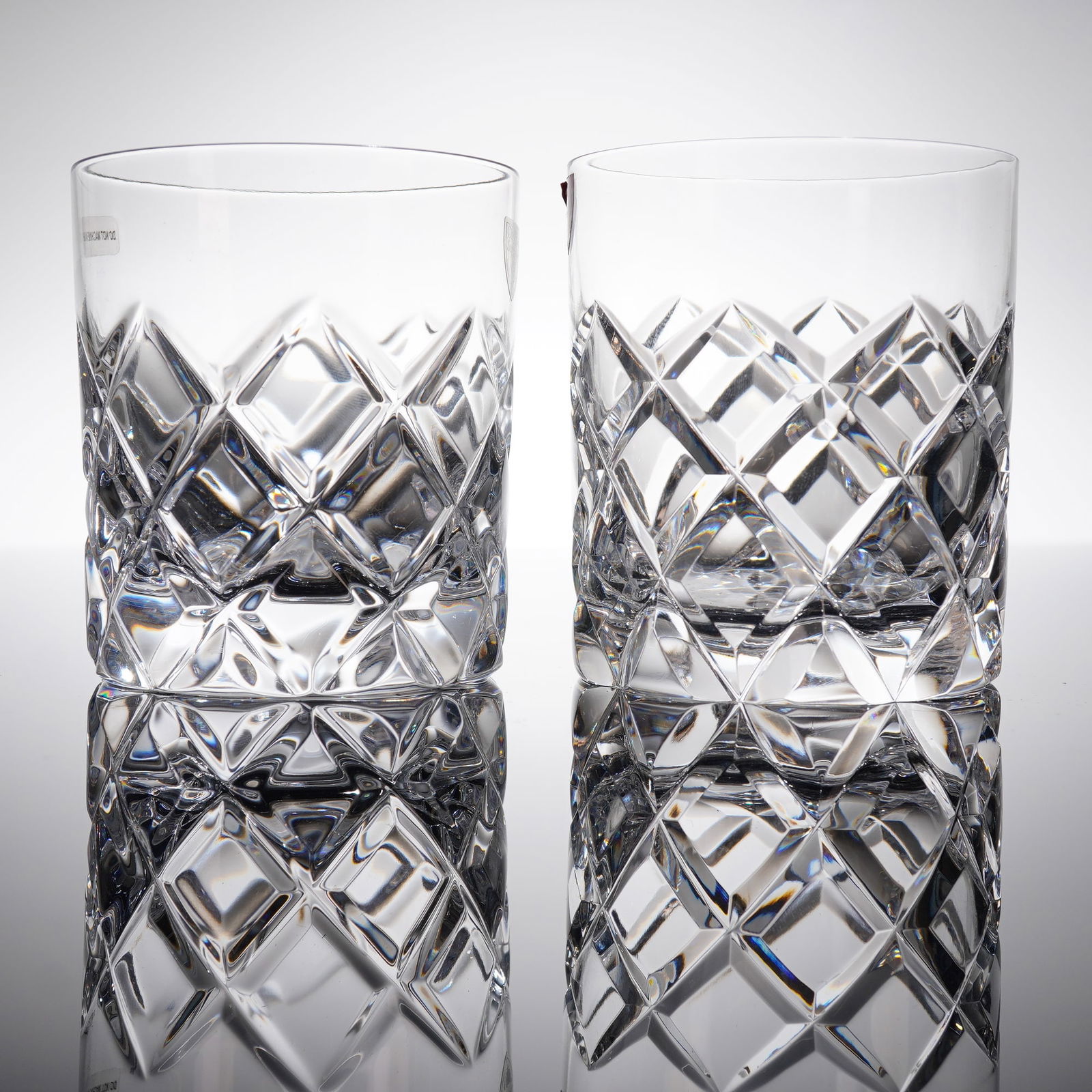 A Pair of Orrefors Sofiero Cut Crystal Double Old Fashioned Whiskey Glasses: A pair of Orrefors Sofiero cut crystal double old fashioned whiskey glasses. These heavy crystal drinking tumblers are characterized by a contemporary style featuring deep, brilliant diamond-cut