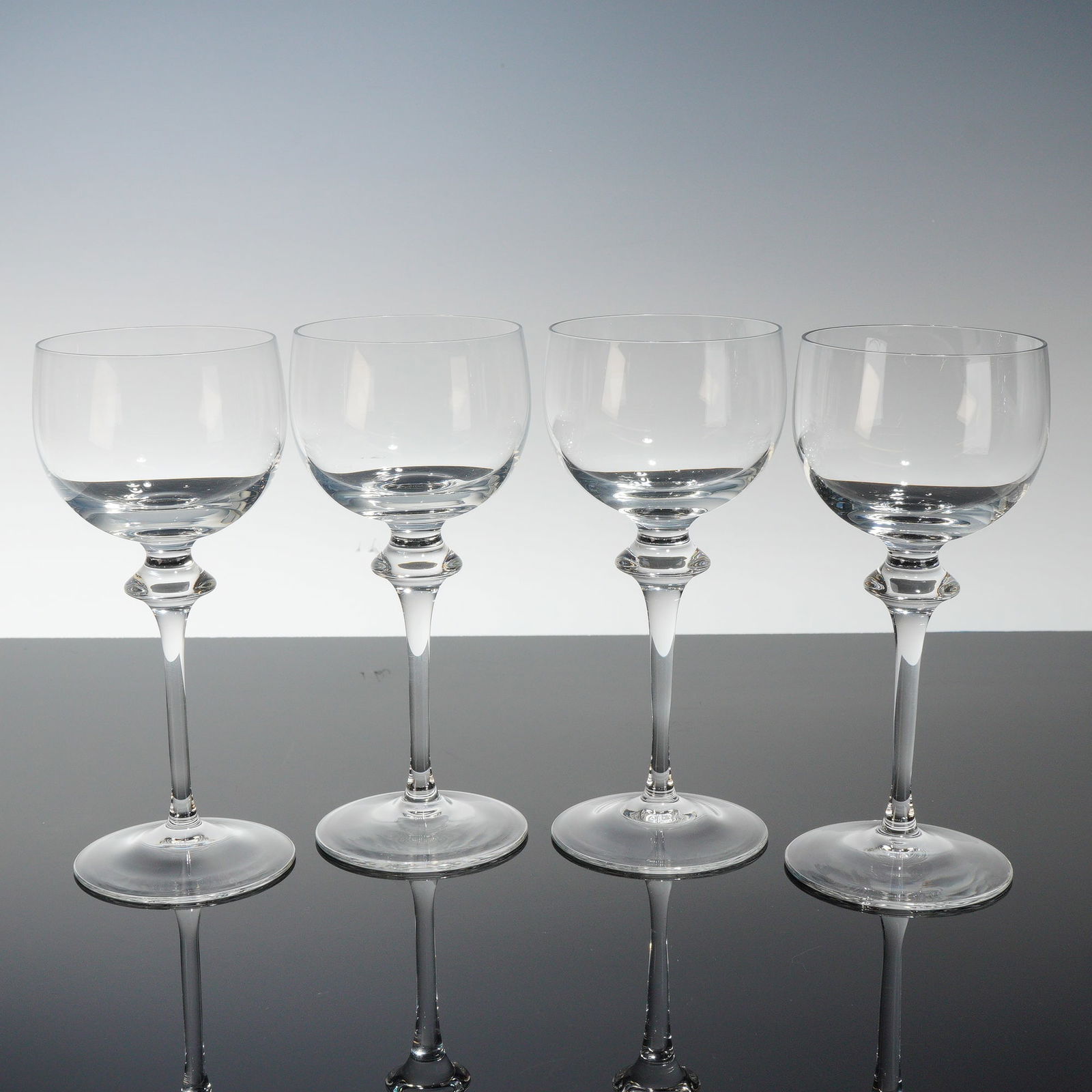 4pc Peill Clear Claret Wine Glasses, Alexa: This lot features a refined four-piece set of Peill clear claret wine glasses in the Alexa pattern, noted for their elegant form and distinctive stem design. Each glass is crafted with a gracefully pr