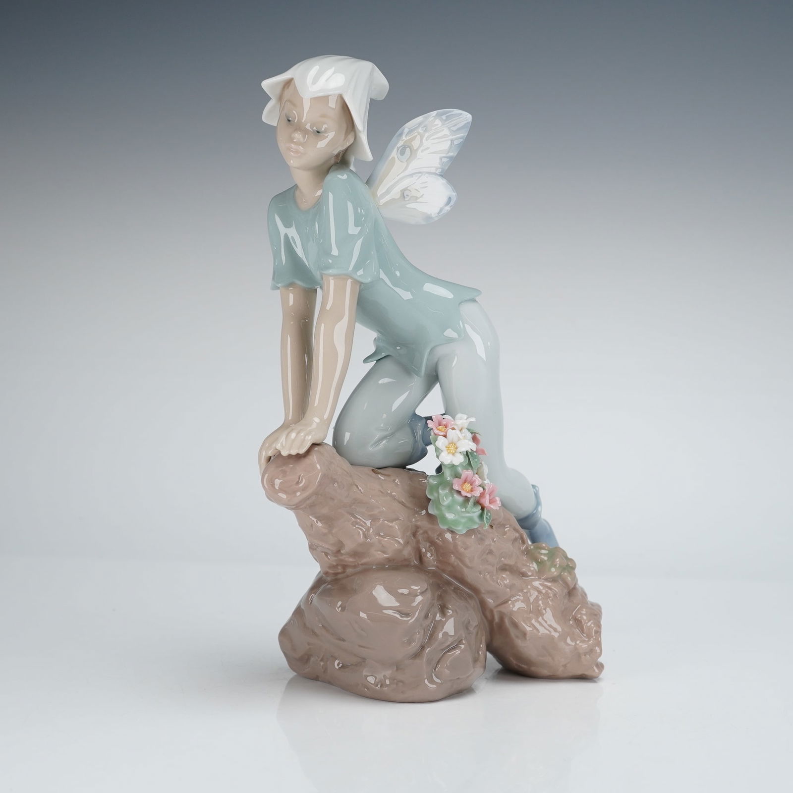 Lladro Prince of the Elves Figurine 1007690: A single glazed Lladro Porcelain Figurine titled Prince of the Elves, model number 1007690. The contemporary sculpture depicts a kneeling male figure, characterized as a sprite or elf, wearing a light