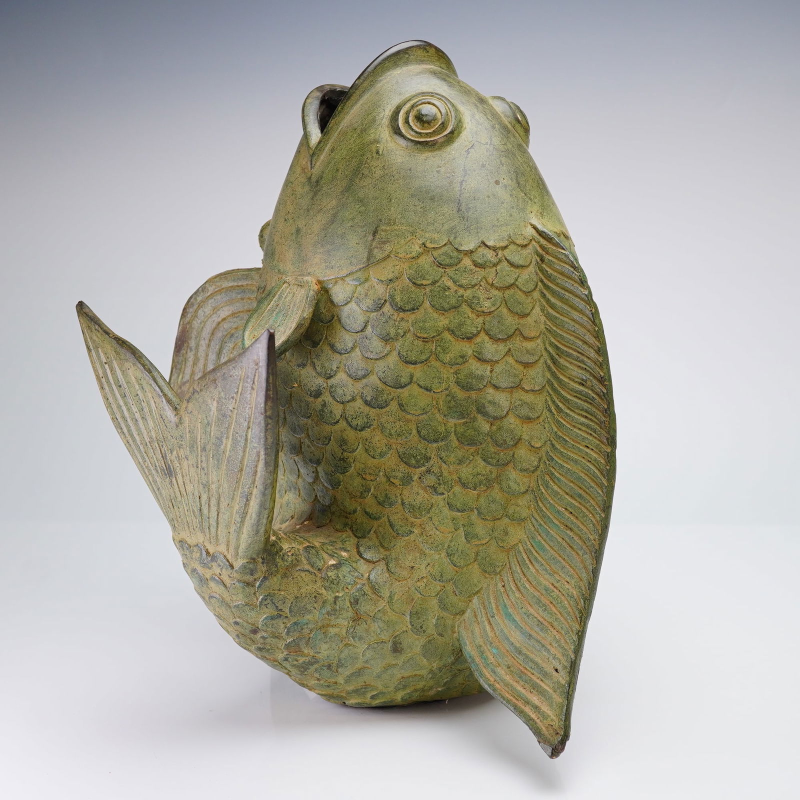 Asian Verdigris Brass Koi Fish Vessel Sculpture: An Asian cast metal brass sculpture modeled in the form of a stout koi fish, designed to stand upright . The koi is depicted with its mouth wide open, suggesting its use as a container or vase. The bo