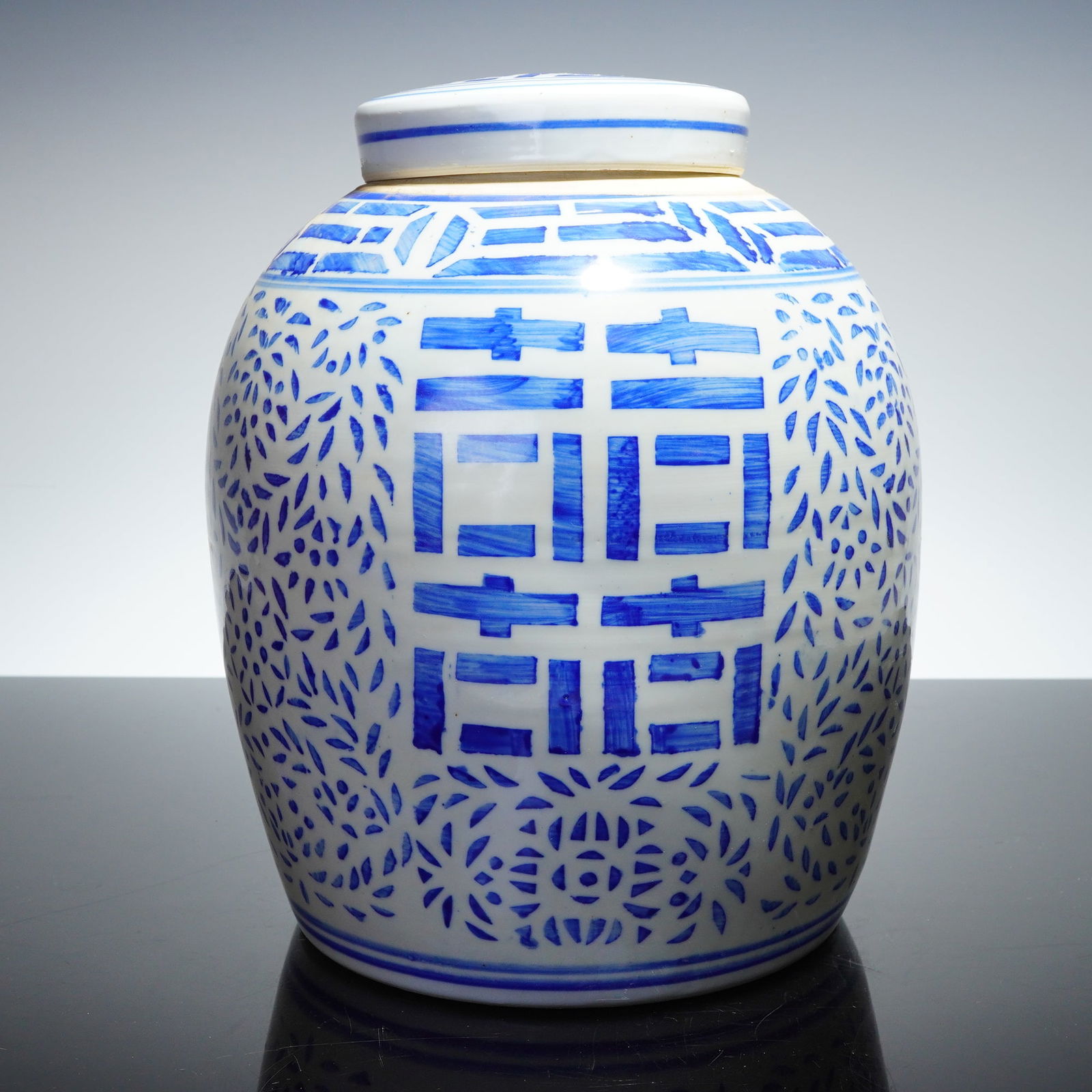 Chinese Blue and White Hand-Painted Double Happiness Ginger Jar: A Chinese blue and white ceramic lidded jar of globular ginger jar form. The vessel features hand-painted underglaze cobalt blue decoration on a brilliant white ground. The main body is decorated with
