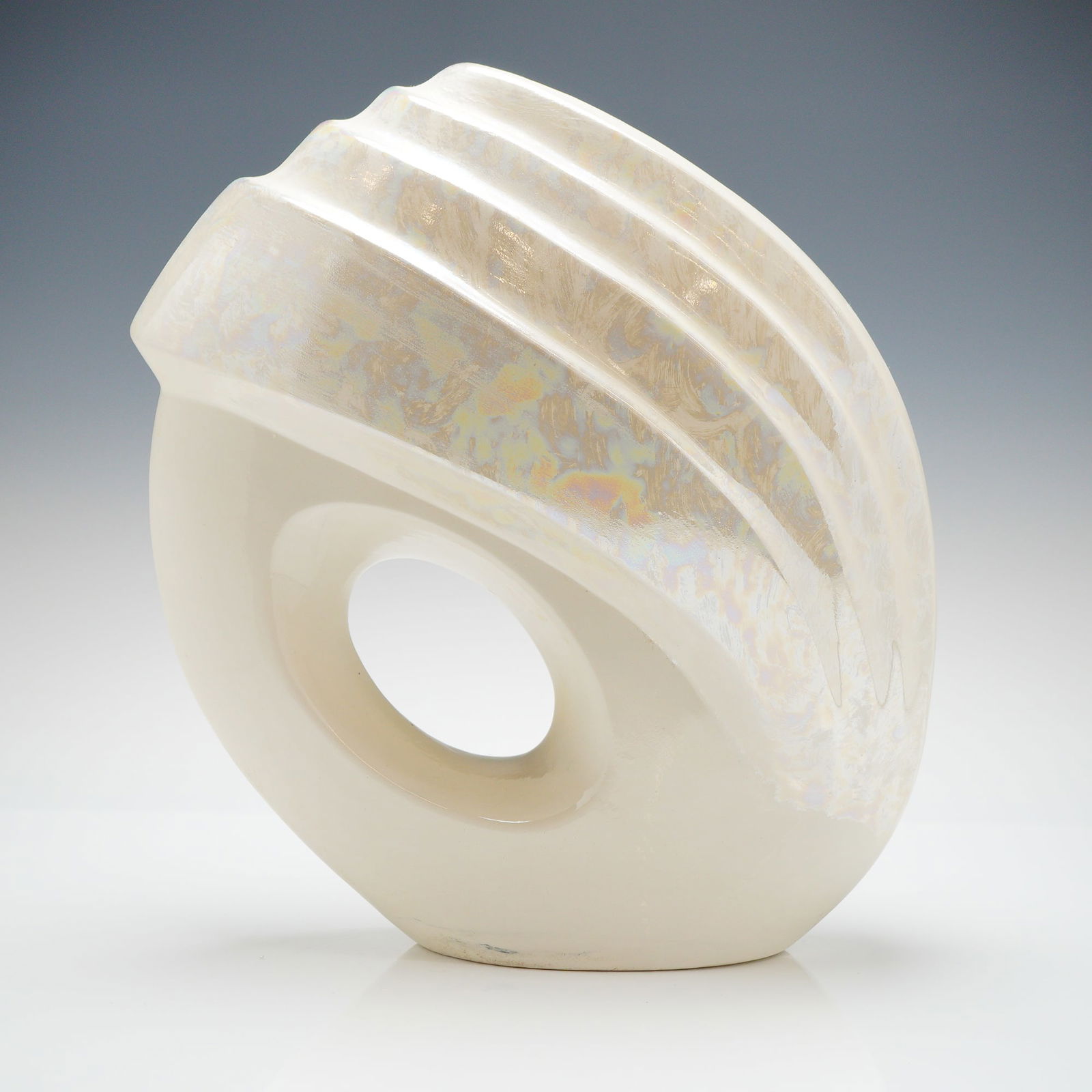 Art Deco Revival Iridescent Ceramic Vessel: A single ceramic sculptural vessel exhibiting a flattened, asymmetrical oval form. The vessel is divided into two distinct textural zones: the lower section, which features a high-gloss solid creamy w