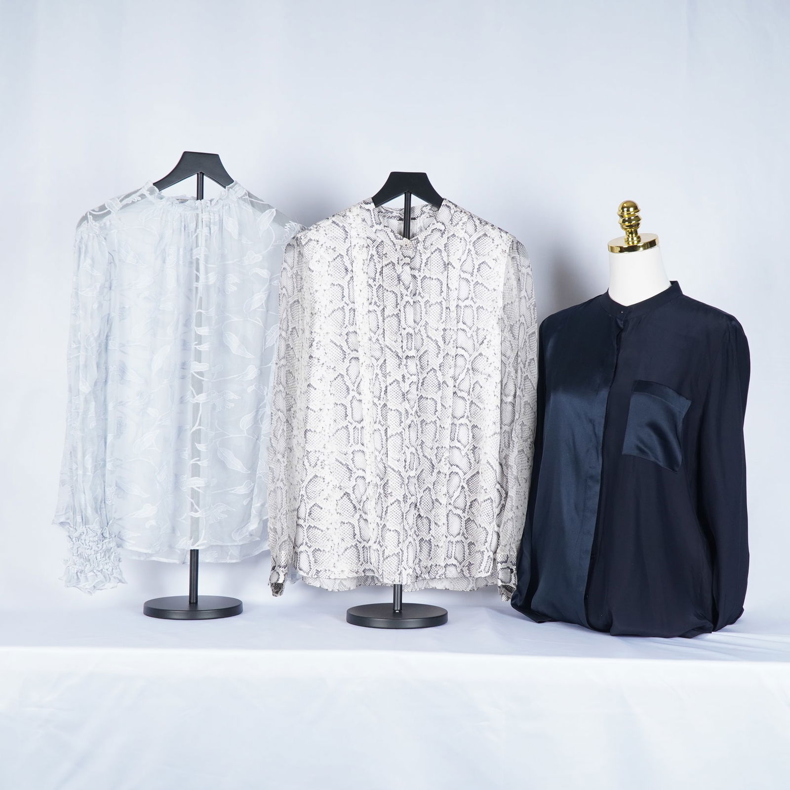 3pc Tahari Women's Silk and Chiffon Blouses: Tahari women's blouses featuring luxe fabrics and elegant textures. Included is a pale blue sheer chiffon blouse with delicate floral applique-style detailing and gathered cuffs, a neutral