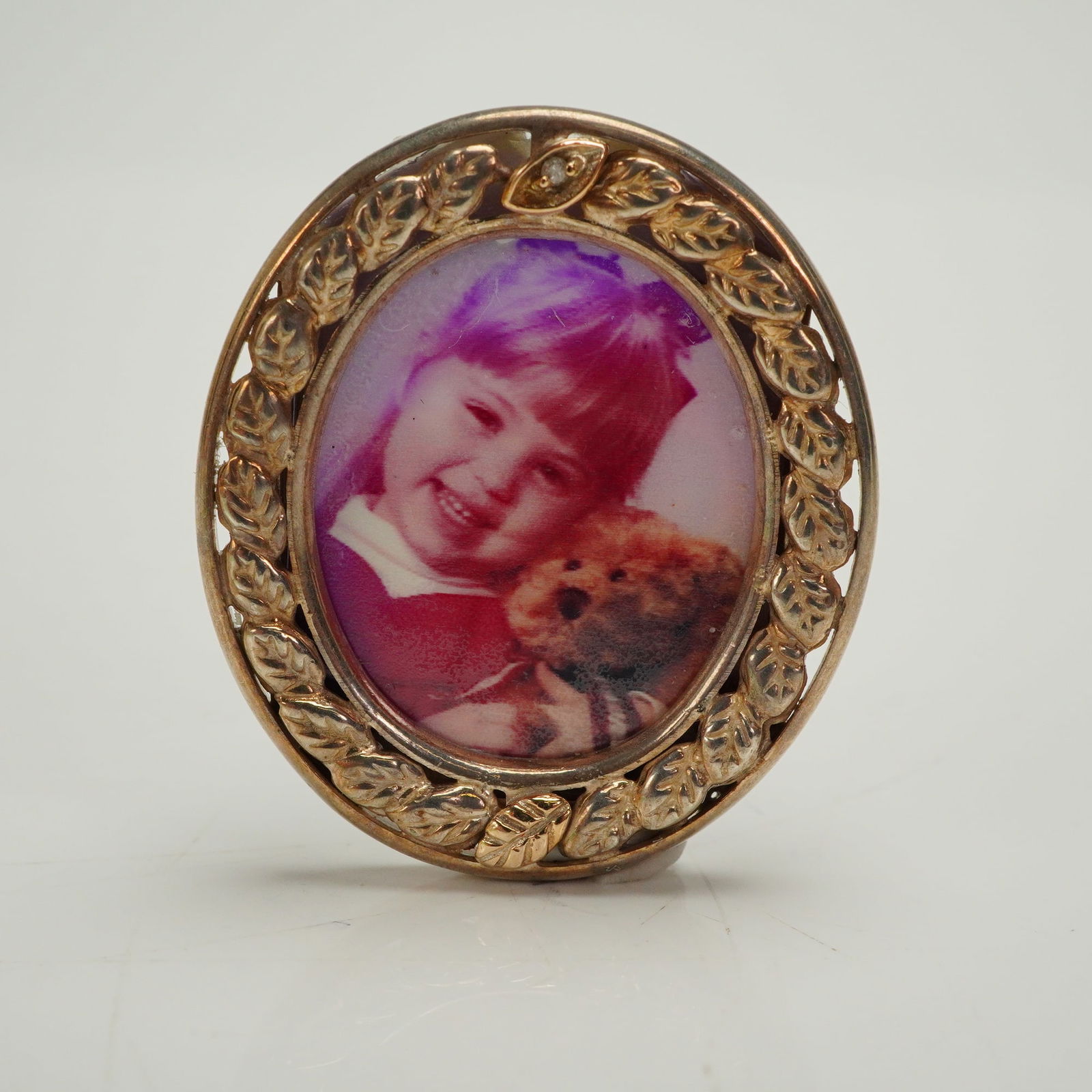 Sterling & 10K Gold Plated Mini Picture Frame Brooch: A convertible miniature photograph frame designed to function as both a brooch/pin and a small tabletop easel frame. The oval frame is constructed of sterling silver with 10K gold plating or overlay,