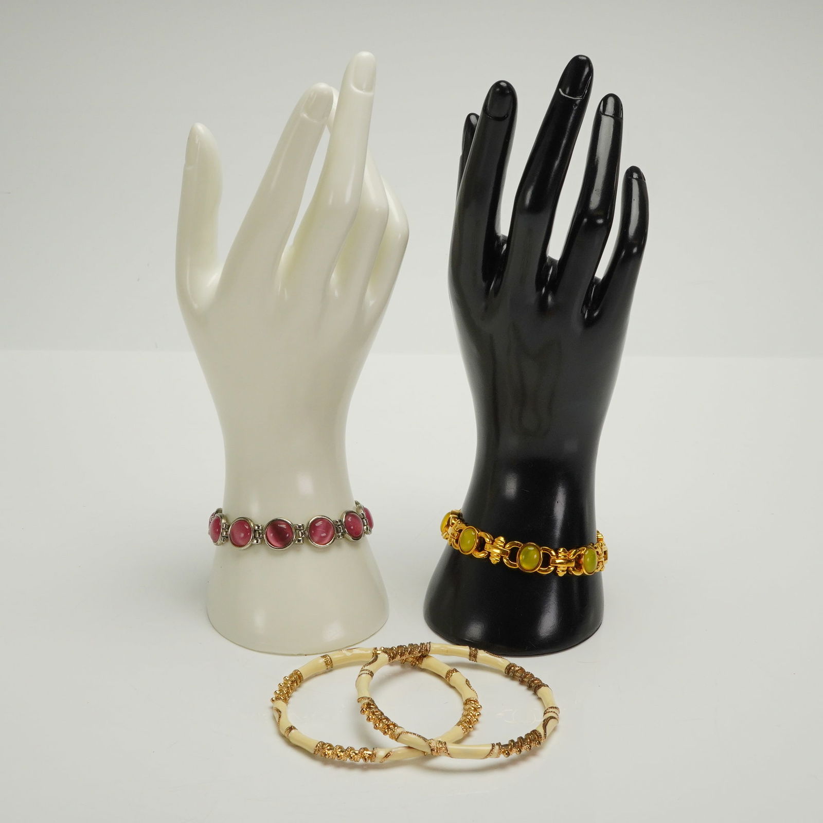 4pc Vintage Costume Bangles and Bracelets: This collection consists of four pieces of costume jewelry, including two link bracelets and two bangles. The first link bracelet is constructed of silver-tone metal settings holding large, round, vib