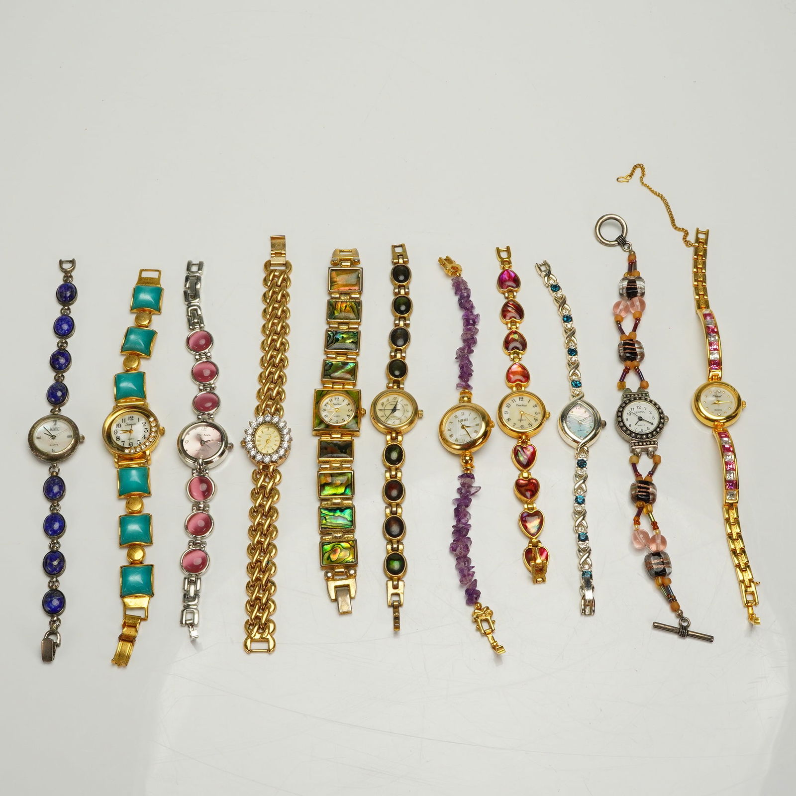 11 Ladies Fashion Wristwatches Gold & Silver Tone Gem Inlaid: A collection of 11 ladies' fashion wristwatches, predominantly featuring quartz movements and highly decorative bracelet styles consistent with contemporary costume jewelry. The watches are