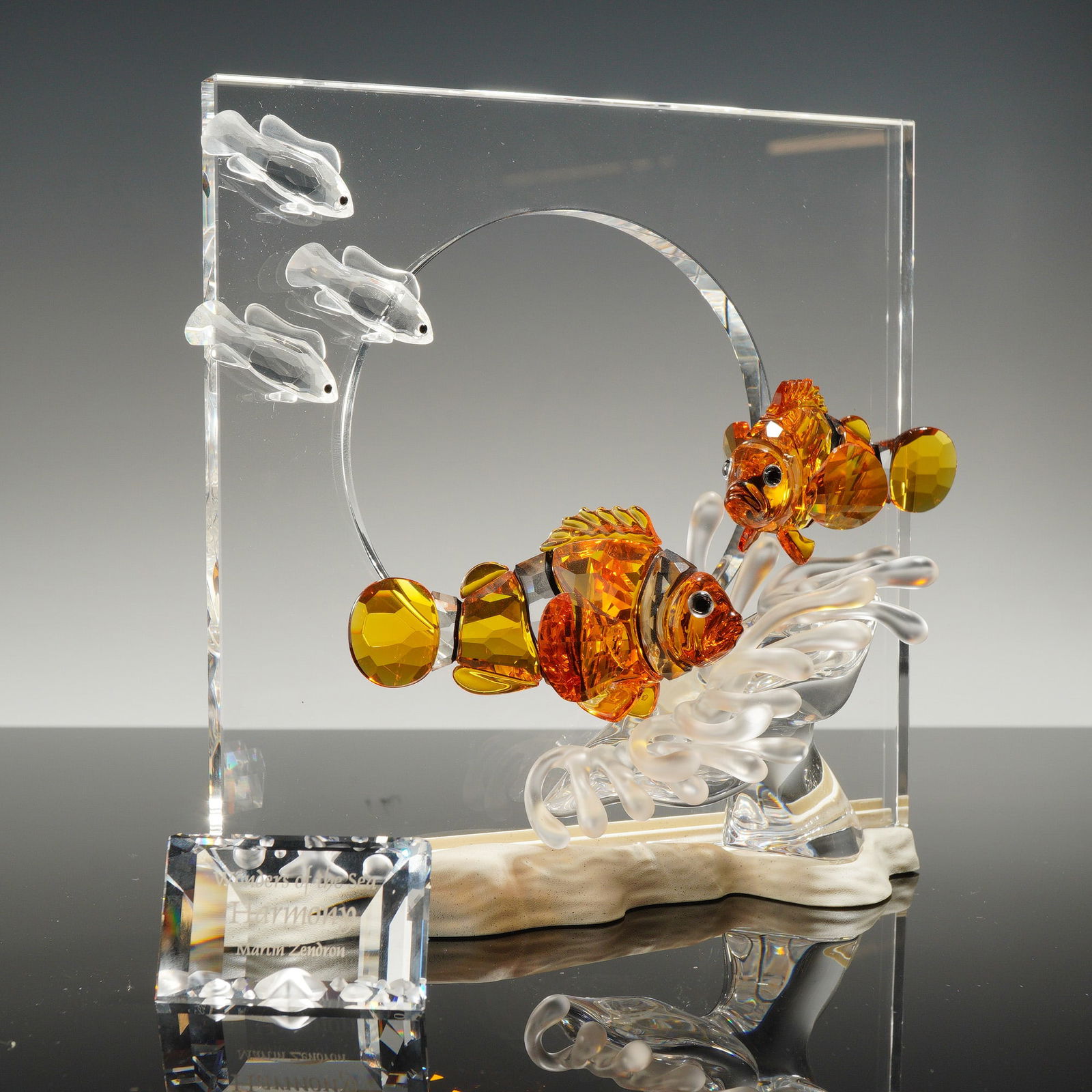 Swarovski Wonders of the Sea Harmony Crystal Sculpture: A Swarovski crystal sculpture titled Harmony from the Wonders of the Sea trilogy, designed by Martin Zendron and released in 2005. The piece features faceted amber and clear crystal clownfish position