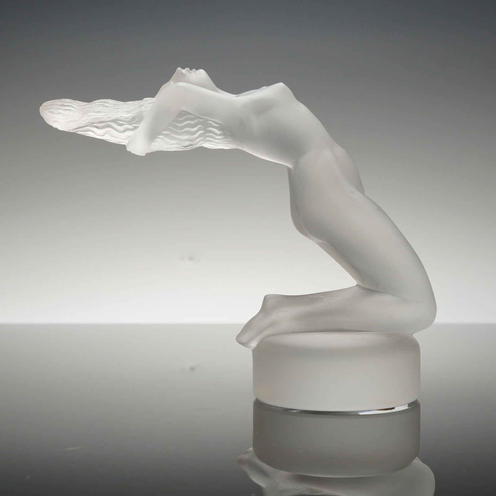 Lalique Crystal Figurine, Chrysis: A Lalique Chrysis crystal figurine. This frosted glass sculpture depicts a kneeling nude female figure in a dynamic pose with her head tilted back and long, textured hair streaming behind. The piece i