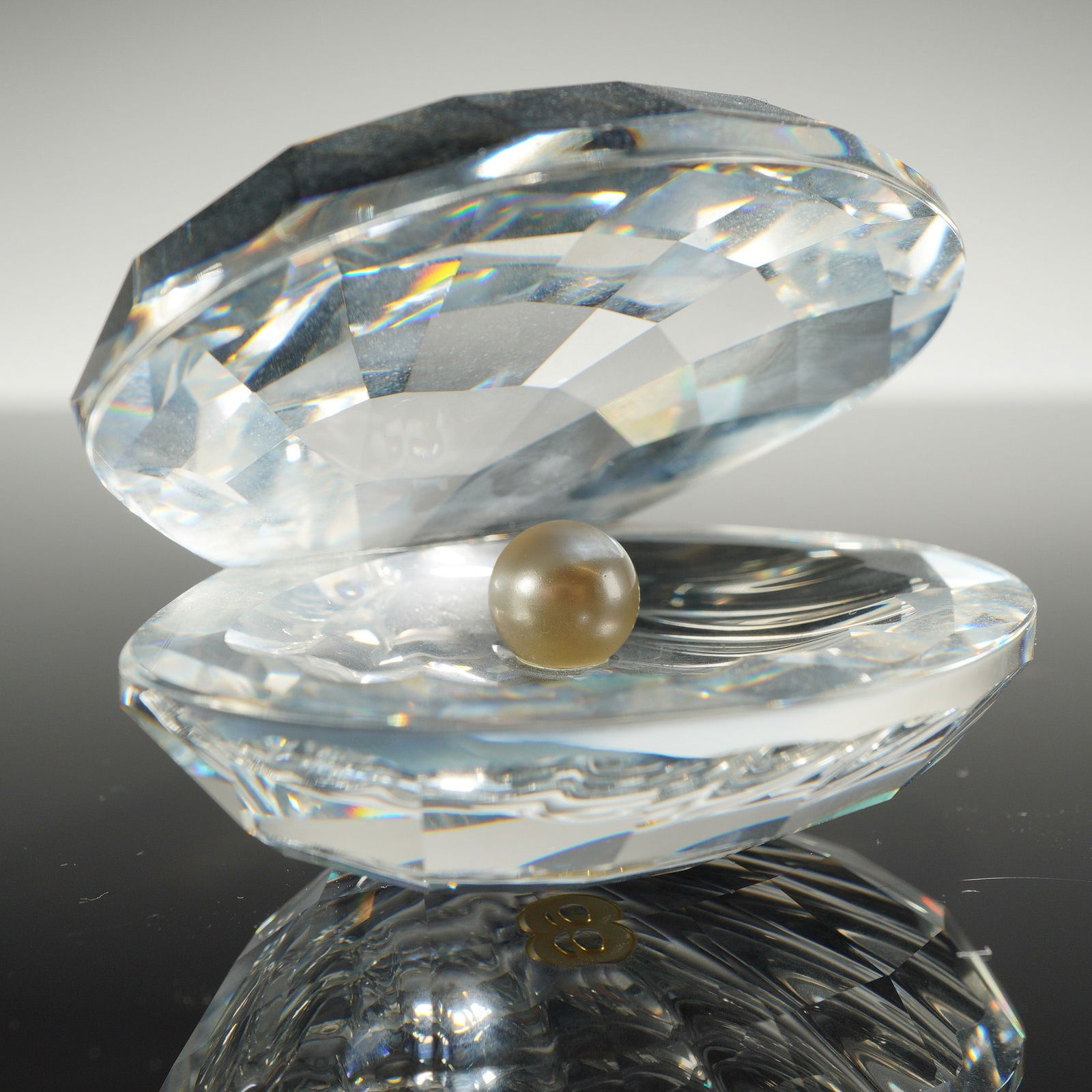 Swarovski Crystal Open Clam Shell with Pearl Figurine: A Swarovski Silver Crystal figurine identified as the Open Clam Shell with Pearl, model number 014389. The object is constructed from multifaceted clear lead crystal in the form of an open bivalve she