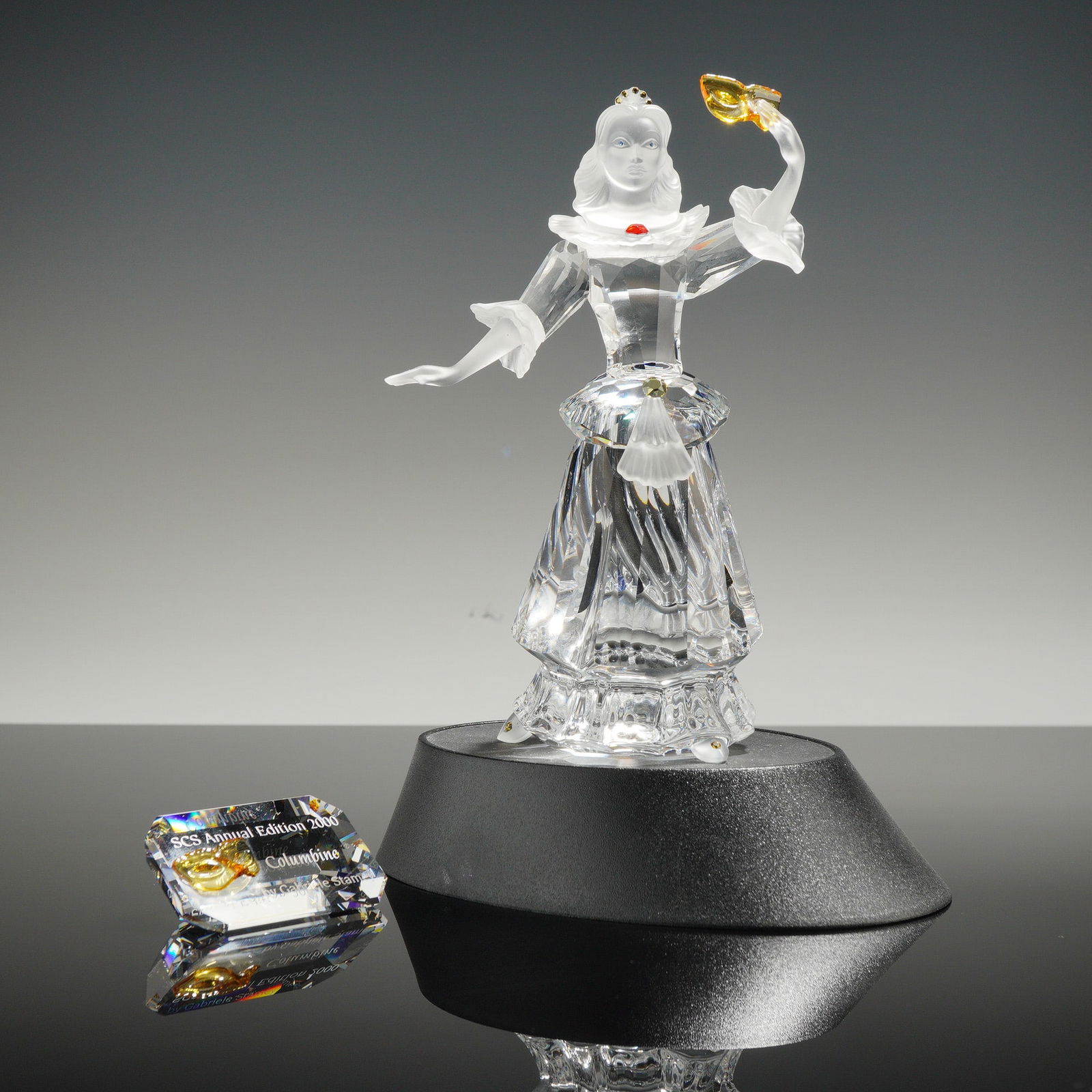 Swarovski Crystal SCS 2000 Annual Edition Masquerade Columbine Figurine: This Swarovski Crystal Society SCS Annual Edition for 2000, titled Columbine, was designed by Gabriele Stamey as part of the Masquerade trilogy. The figurine is constructed from clear faceted crystal
