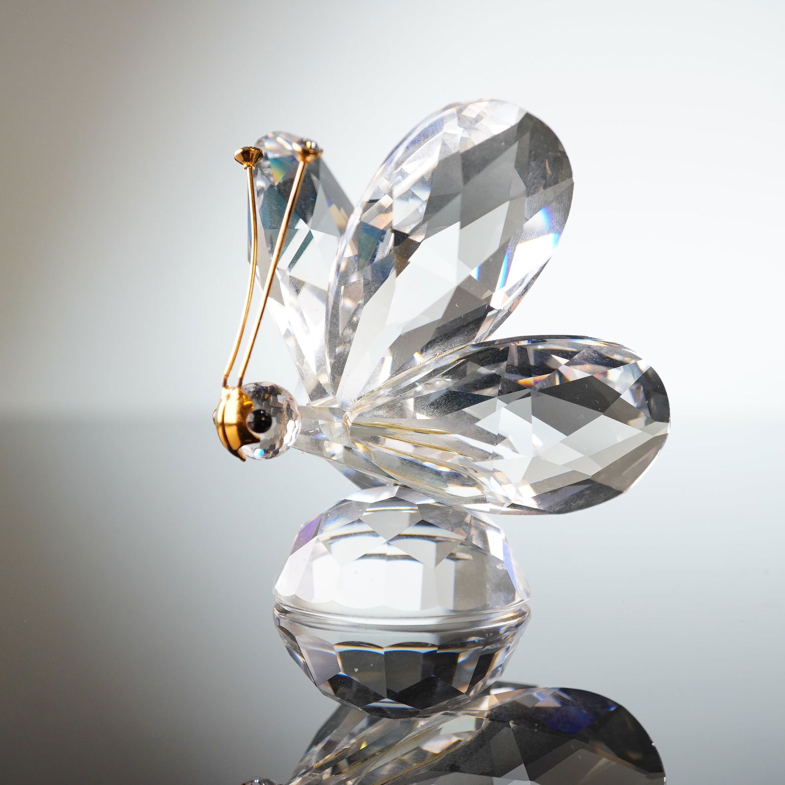 Swarovski Large Butterfly Figurine, Gold Antennae and Crystal Tips: Swarovski crystal Large Butterfly figurine, distinguished by its gold-tone antennae with clear crystal tips and a large gold mask nose that covers much of the face. The butterfly features black