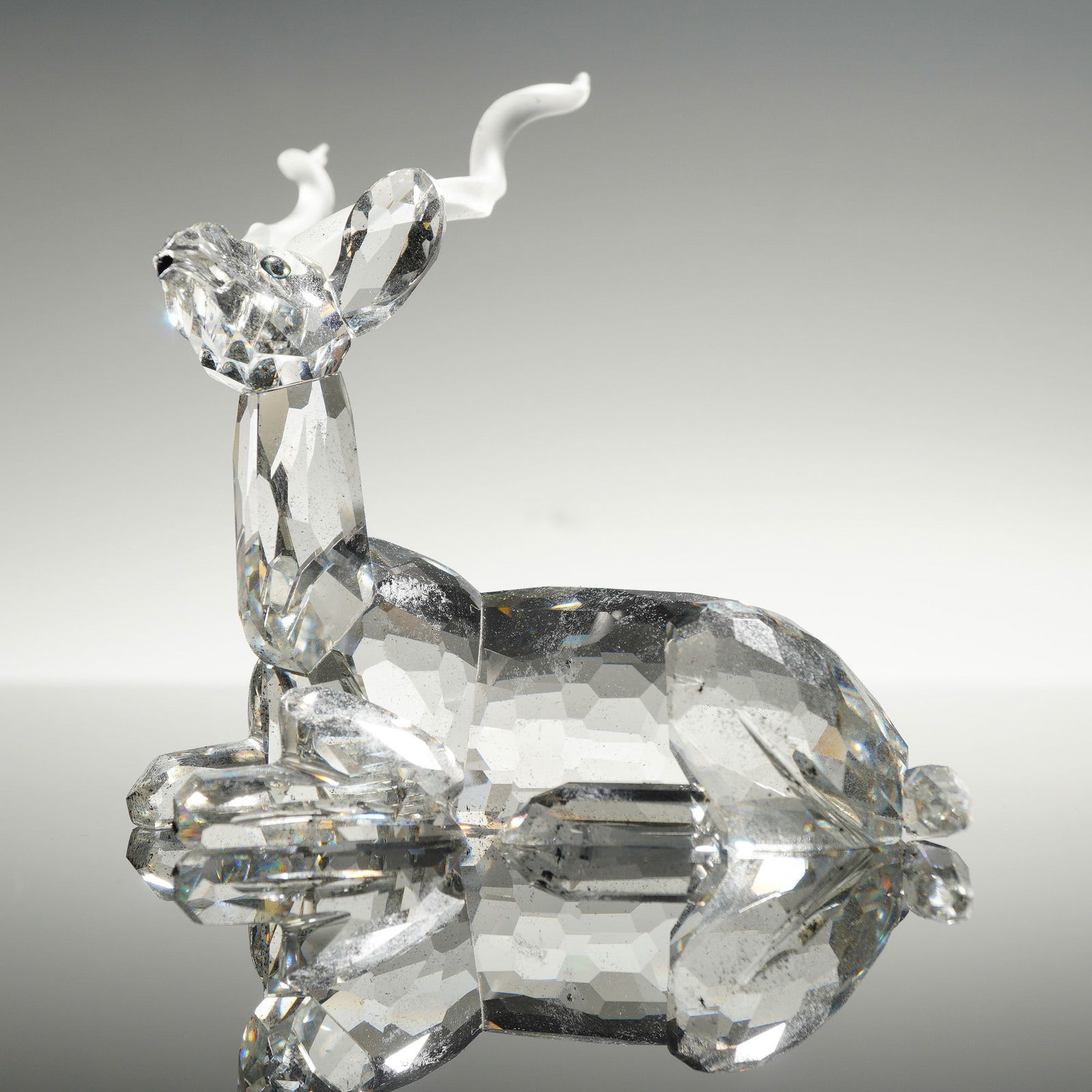 Swarovski Silver Crystal, Inspiration Africa Kudu Figurine: This Swarovski crystal figurine, titled Kudu, is from the 1994 Annual Edition Inspiration Africa series. The piece is constructed from clear faceted lead crystal and depicts the animal in a recumbent