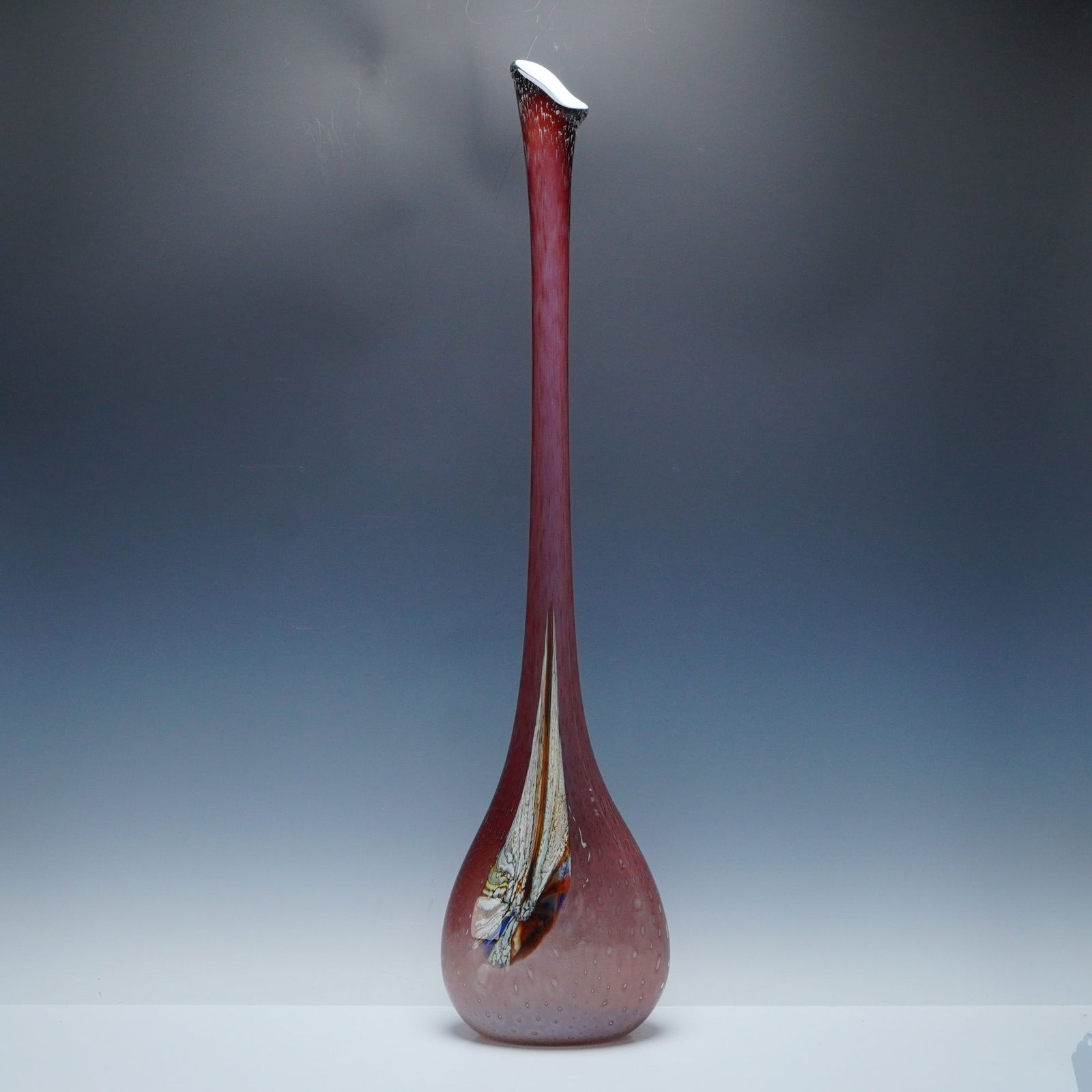 Mauve Tear Drop Art Glass Floor Vase: An elongated, tapering neck rising from a rounded base, executed in a rosy-mauve hue with evenly spaced controlled bubbles throughout the body. The front displays an internal abstract multicolor