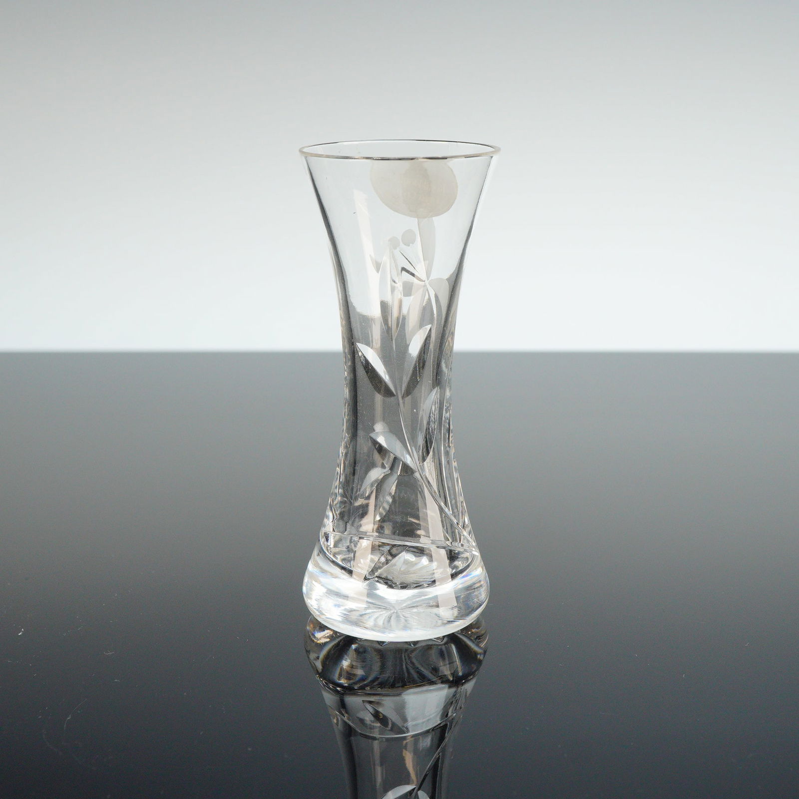 Royal Doulton Crystal Bud Vase, Orchid: The piece is composed of hand-cut lead crystal and features an hourglass-shaped body with a flared rim. The exterior is decorated with a hand-cut floral and foliate design depicting an orchid bloom.