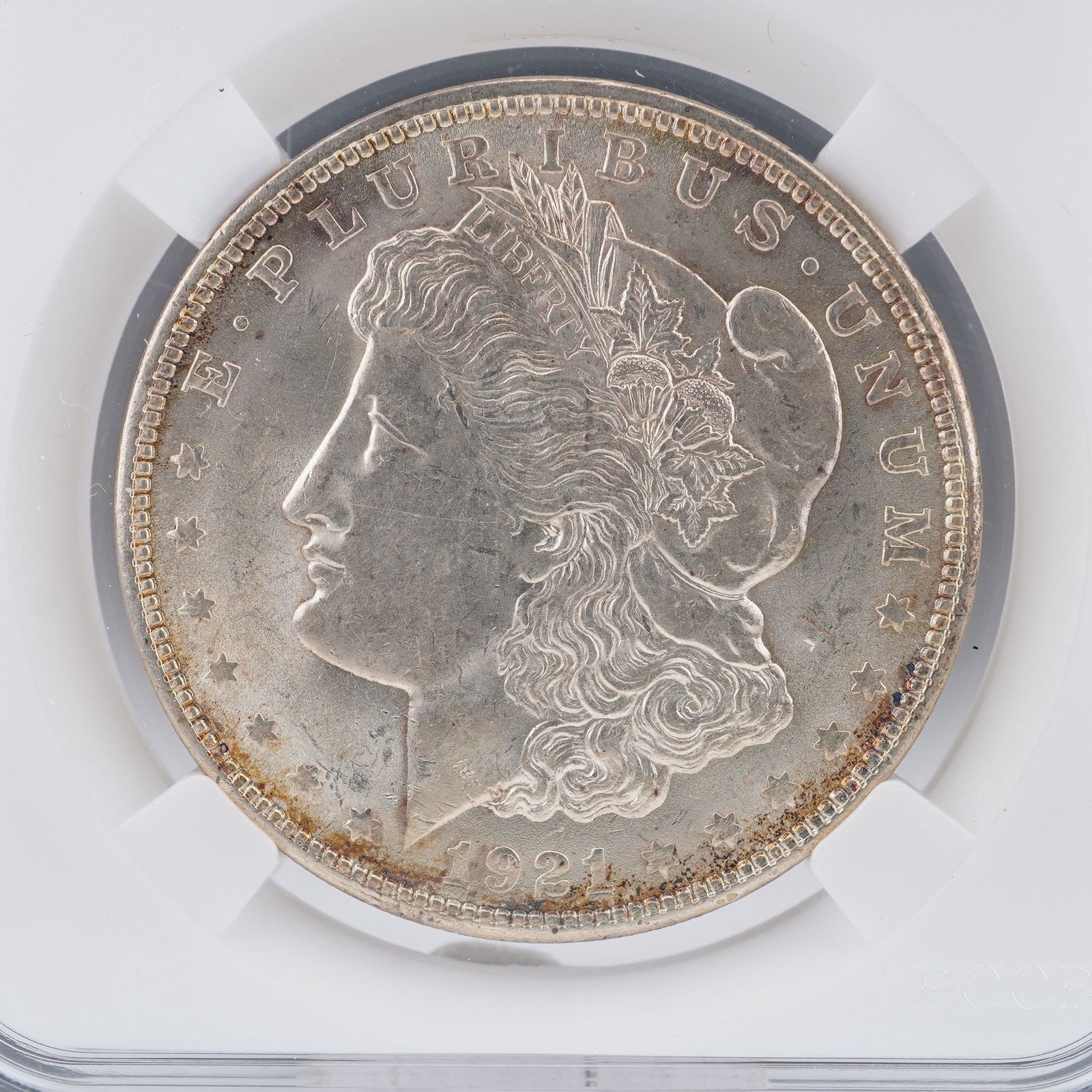 1921 Morgan Silver Dollar: Presented is a 1921 Morgan Silver Dollar, struck from ninety percent silver and ten percent copper. The obverse features George T. Morgan's neoclassical profile of Liberty, crowned with a Phrygian cap