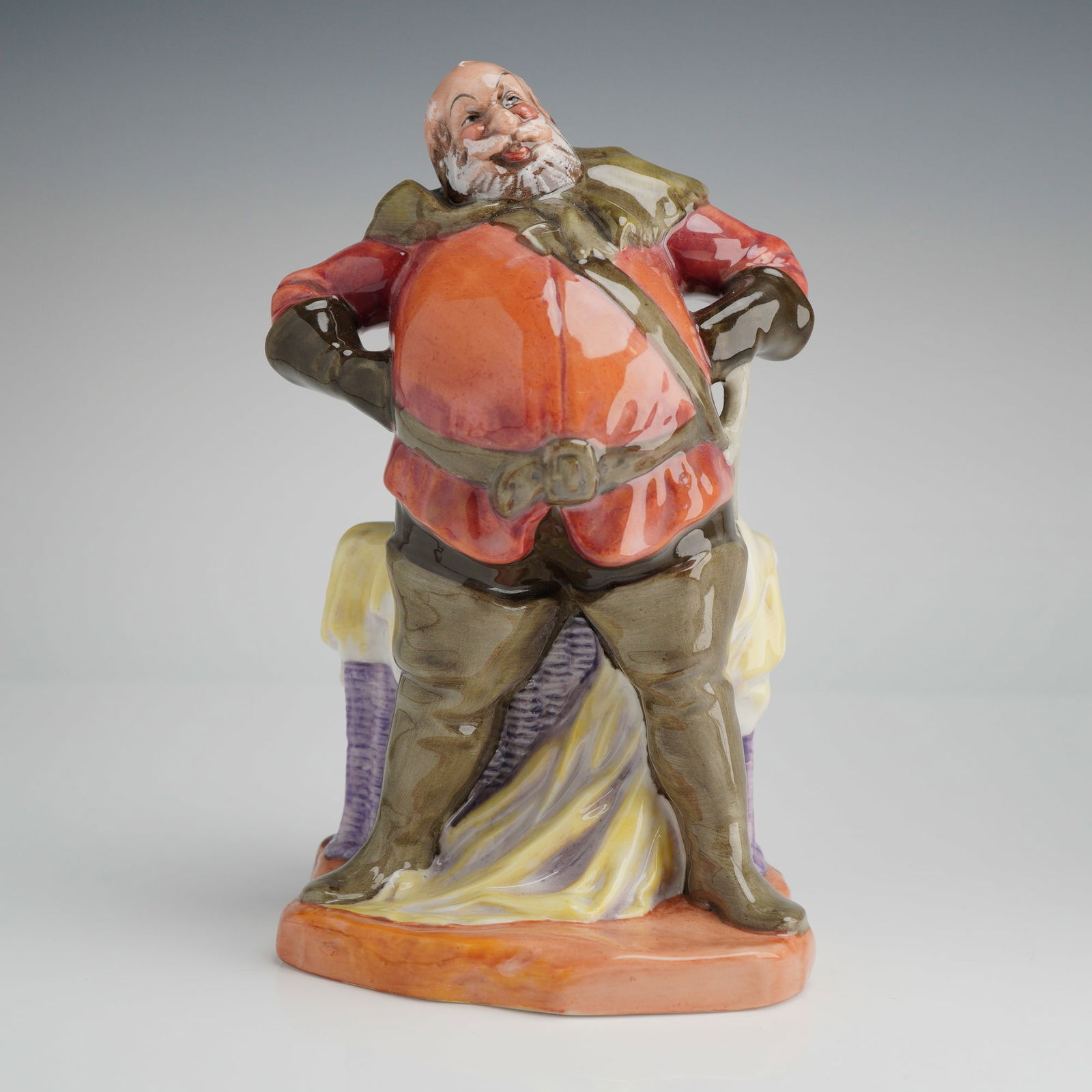 Royal Doulton Falstaff HN2054 Porcelain Figurine: A Royal Doulton porcelain figurine titled Falstaff, model number HN 2054. This character study depicts the Shakespearean figure in a standing pose with hands on hips. The figure is modeled wearing a r