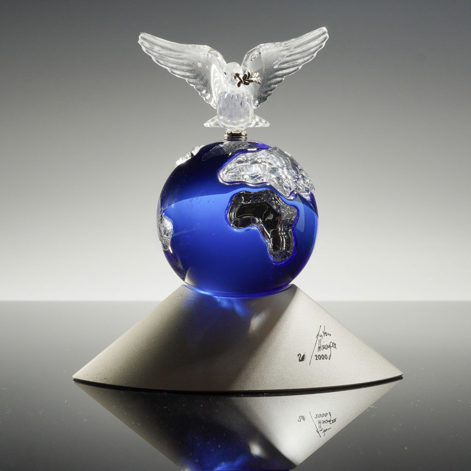 Swarovski Crystal Planet Figurine: Swarovski Crystal Planet figurine, model number 238985, designed by Anton Hirzinger as a commemorative edition for the year 2000. The sculpture features a clear faceted crystal dove with a silver-tone
