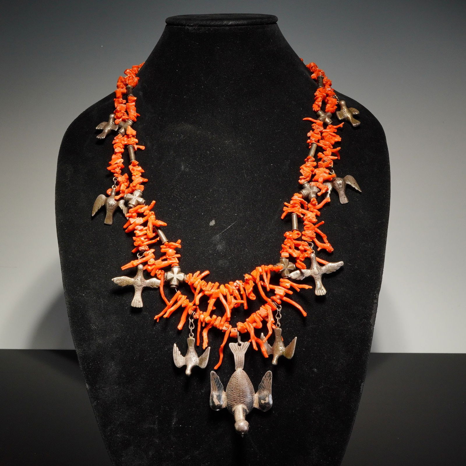 Coral Bead Necklace with Metal Bird Charms: This double-strand necklace is composed of numerous branches of natural red coral. The design features multiple silver-tone metal bird charms of varying sizes, each displaying incised wing and feather