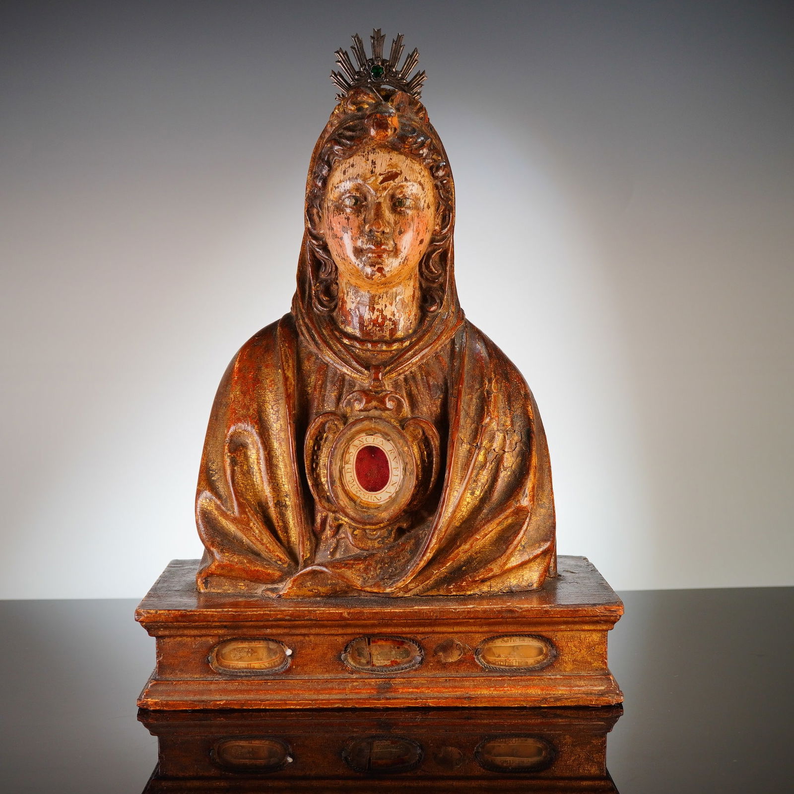 Spanish Gilded Wood Reliquary Bust of Saint Rufina: A Spanish 17th century carved wood reliquary bust of Saint Rufina, virgin and martyr. The figure is executed in a polychrome and gilded estofado finish, depicted wearing a veil and a draped mantle. Th