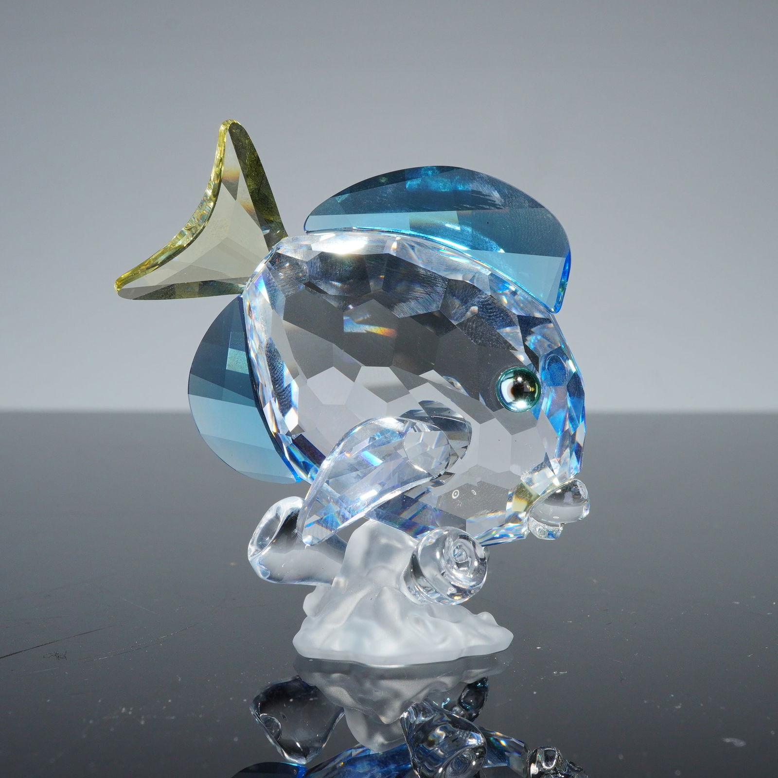 Swarovski Crystal Figurine, Wonders of the Sea, Blue Tang Fish: A Swarovski crystal figurine depicting a Blue Tang fish, part of the Wonders of the Sea collection. The piece is constructed from faceted clear crystal with integrated blue and yellowish-green crystal