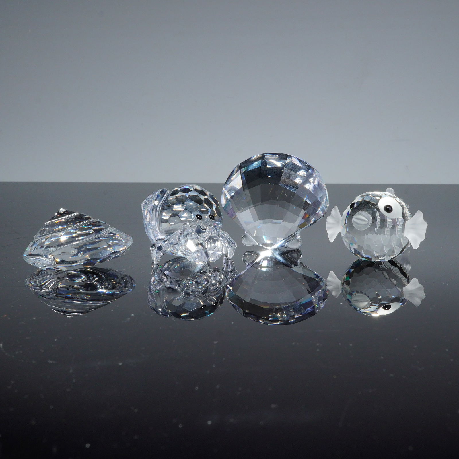 4pc Swarovski Silver Crystal Figurines, Marine Life: A collection of Swarovski faceted lead crystal figurines from the Silver Crystal line, featuring a marine life theme. The group includes a pufferfish with frosted fins and applied eyes, a crab with bl