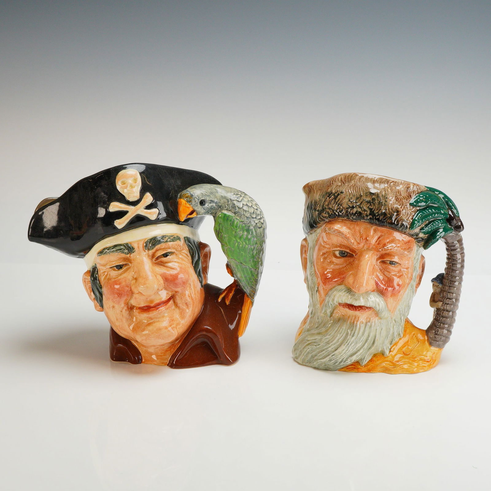2pc Royal Doulton Character Jugs, Robinson Crusoe and Long John Silver: This 2pc set of Royal Doulton character jugs features figures from classic literature, specifically Robinson Crusoe and Long John Silver. Both items are crafted from ceramic with a vibrant polychrome