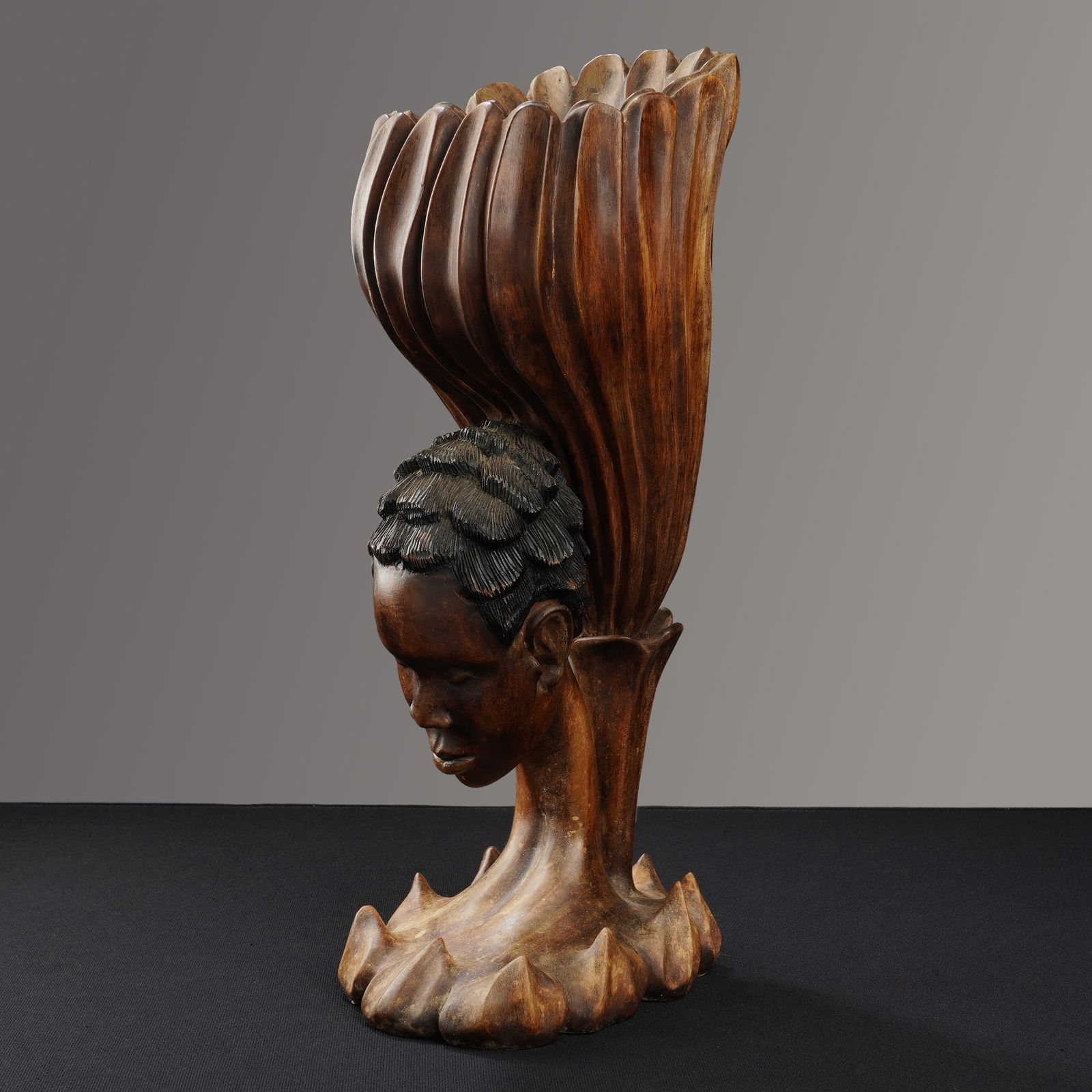 L.S. Decimus (Haiti, 20th Century), Hand-Carved Wood Sculpture of a Woman: This hand carved wooden sculpture of a woman, by Haitian artist LS Decimus, is designed as a sculptural bust. The object is carved from a single piece of wood with a dark brown finish. The form depict
