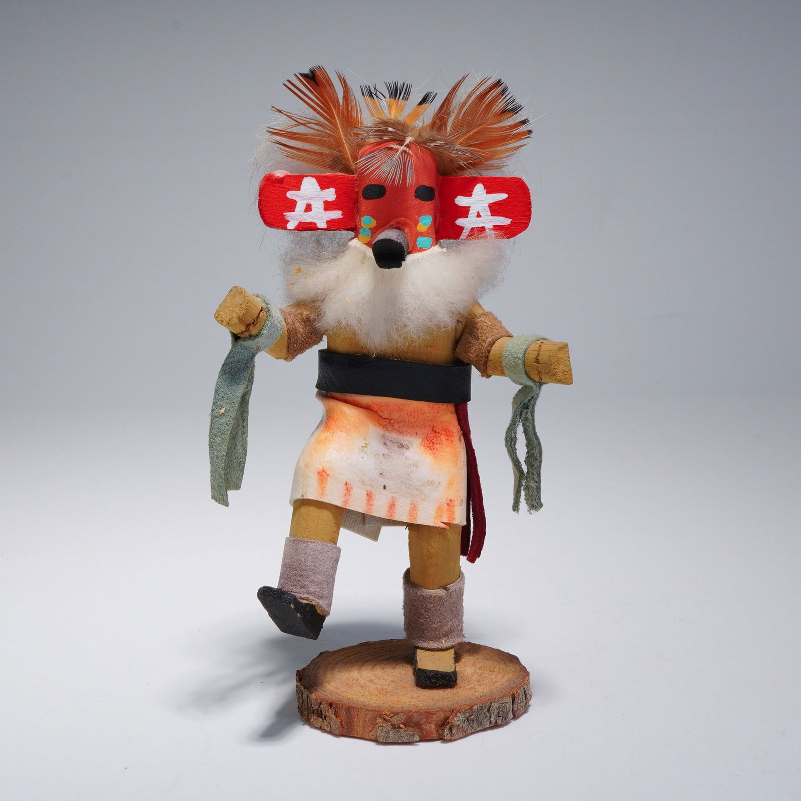 Native American Hopi Kachina Doll Dancing Silent Warrior: This Native American Hopi Kachina doll is a representation of a dancing silent warrior. The figure is hand-carved and hand-painted, mounted on a natural circular wood cross-section base with bark. The