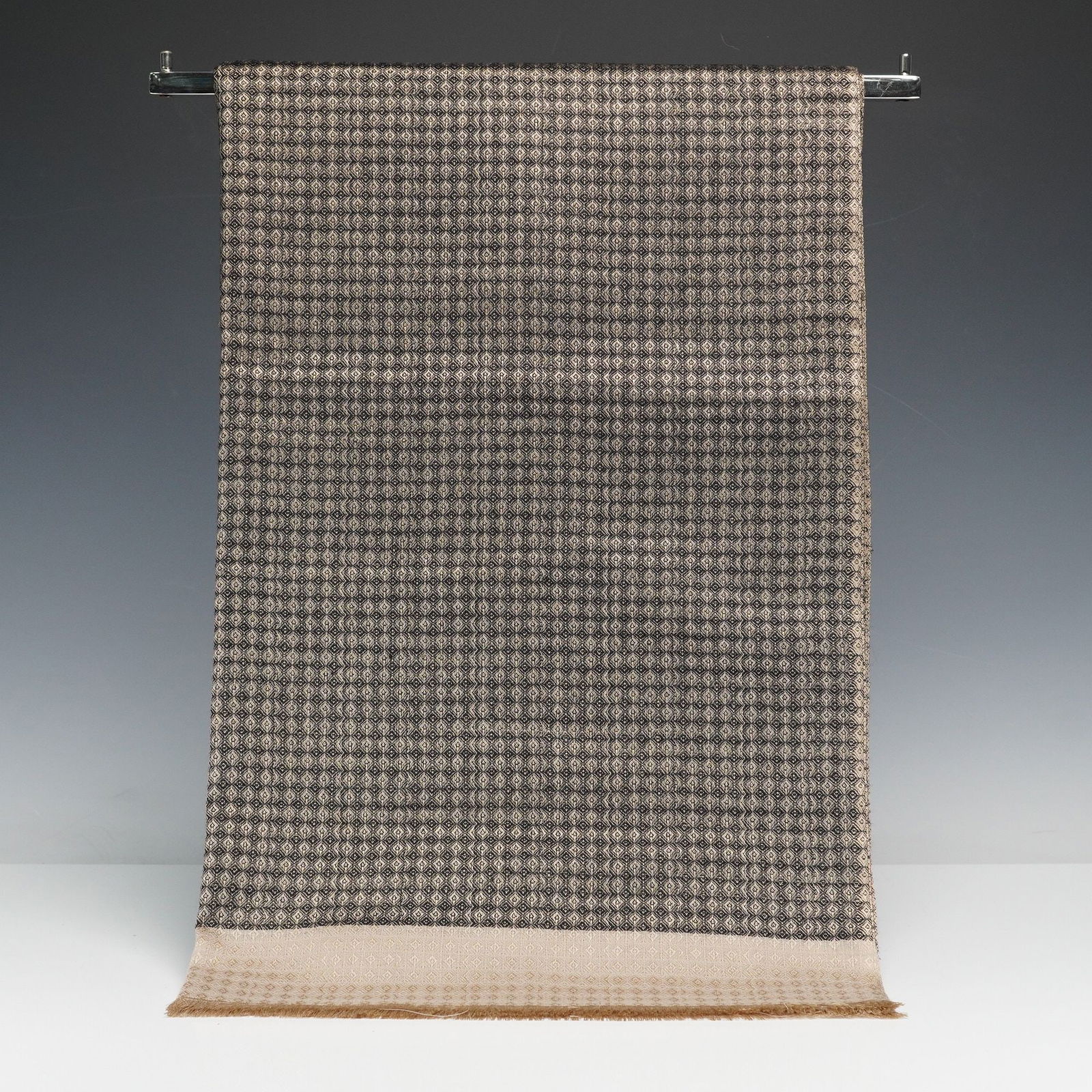 Valentino Garavani Wool and Silk Blend Geometric Scarf or Shawl: A contemporary Valentino Garavani luxury scarf or shawl. Crafted from a blend of 55% wool and 45% silk, the textile features a repeating, tightly woven geometric pattern of interlocking diamonds in a