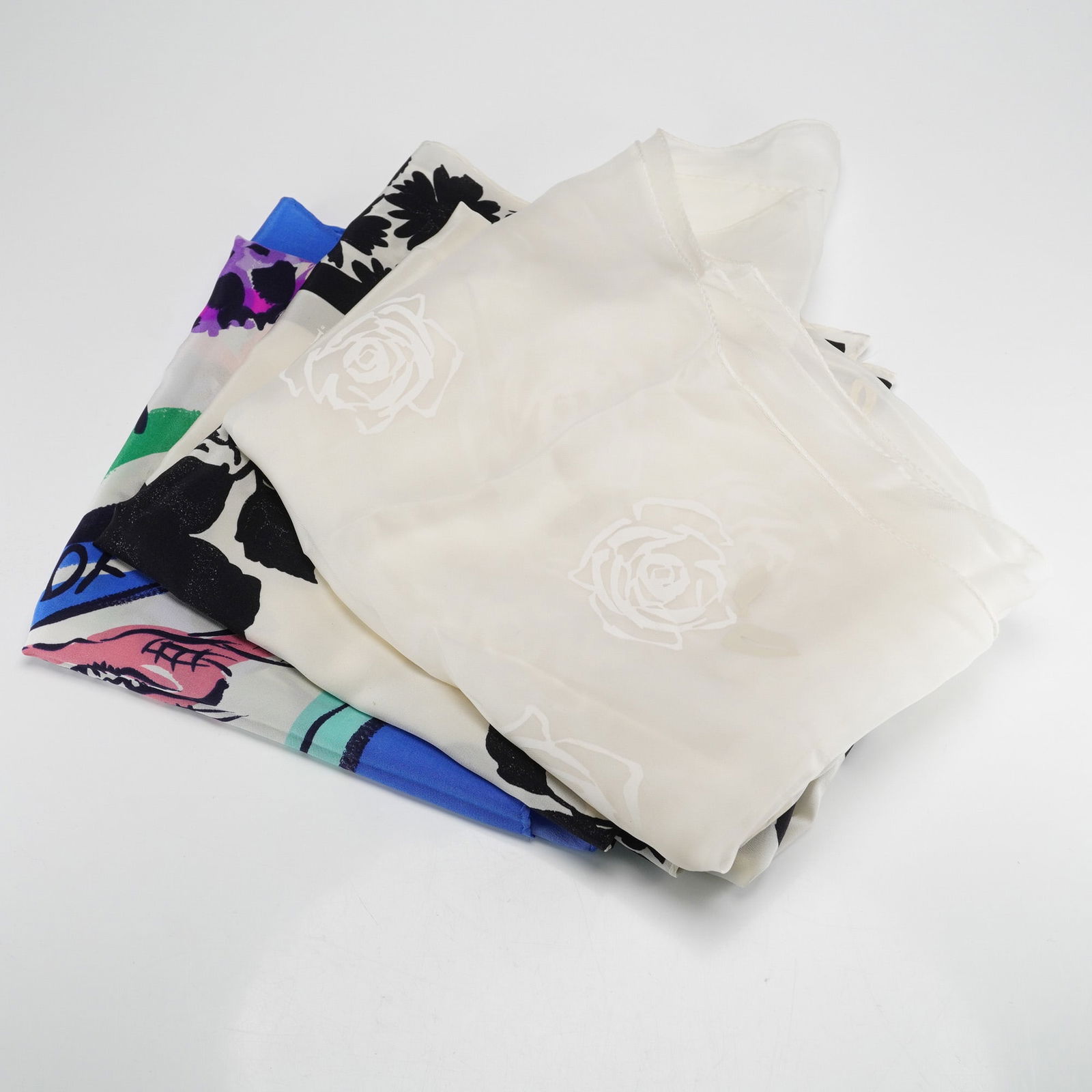 3pc Ecada Silk Scarves, Floral & Animal Motifs: A group of three Escada silk scarves that includes one vibrant, multi-color scarf featuring a playful illustrative style with animals, various botanical elements, and bold text including ZOO, INTERNAT