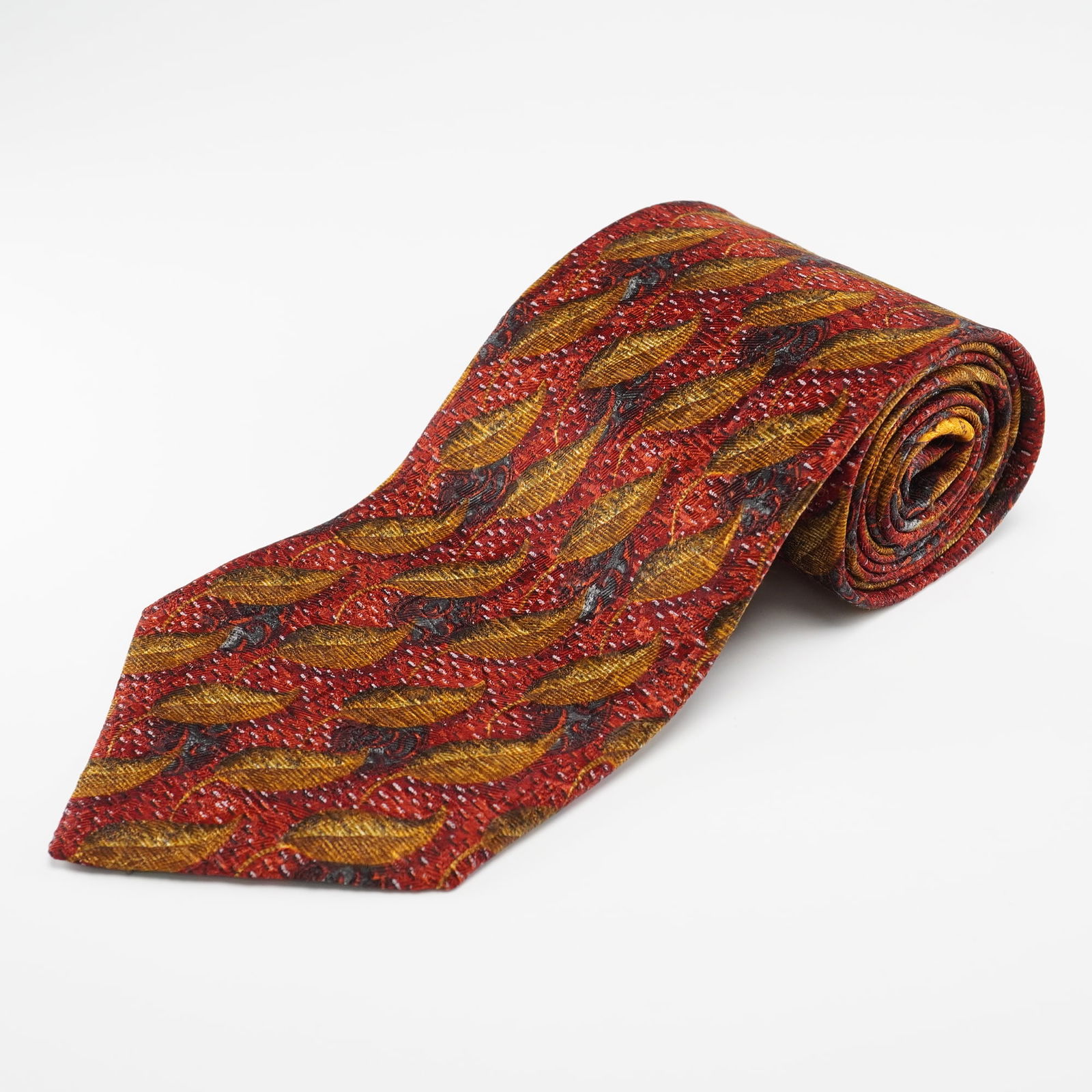 Ermenegildo Zegna Mens 100% Silk Tie, Made in Italy: An Ermenegildo Zegna mens 100% silk tie, made in Italy. The tie features a woven pattern of stylized, elongated leaf motifs in a palette of reds, golds, browns, and black, interspersed with small whit