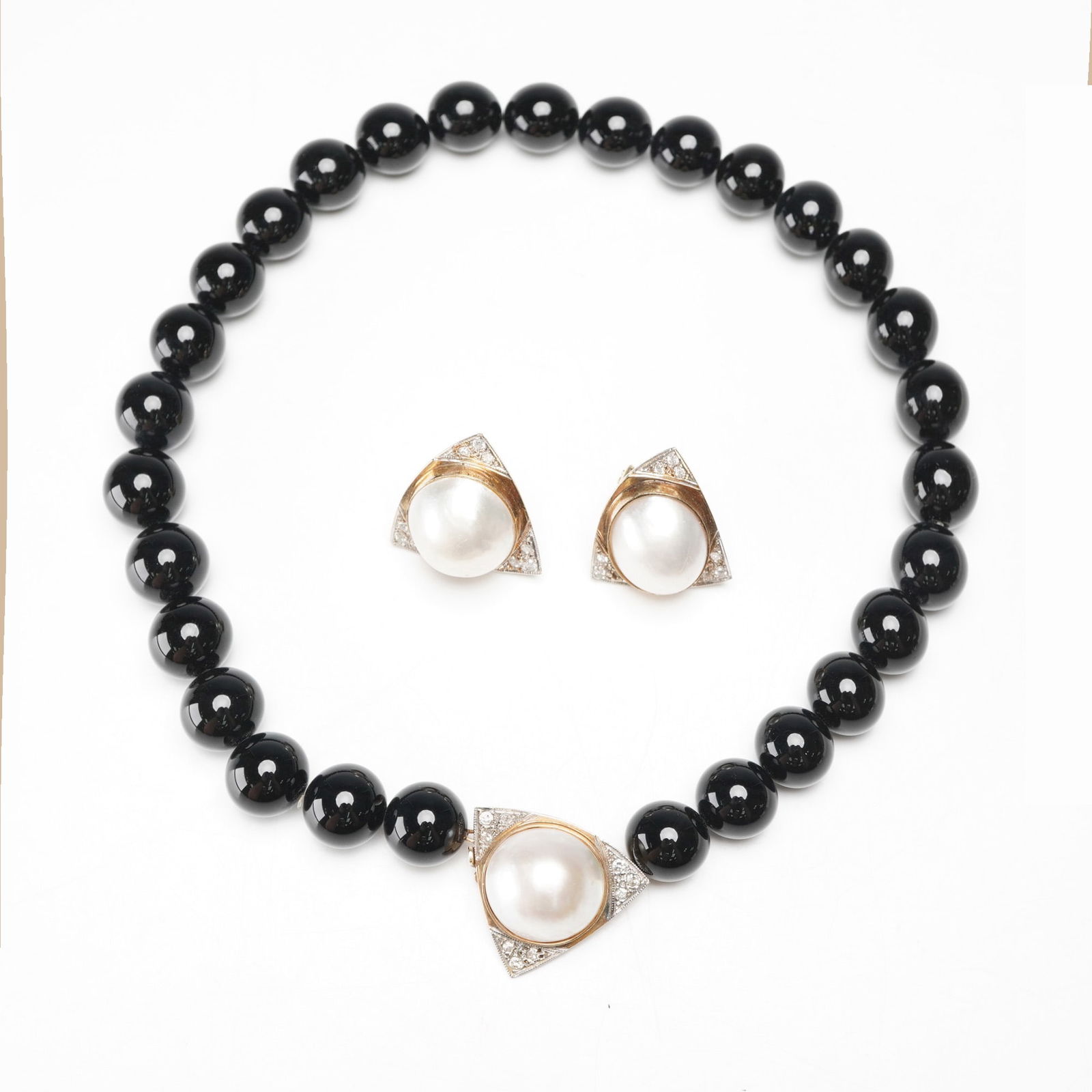 14K Gold Onyx and Pearl Bead Necklace and Earrings: A 3-piece set comprising a black onyx beaded necklace with a triangular 14K gold and pearl centerpiece, together with a pair of matching omega clip-back earrings. The earrings are marked 14K. Measurem
