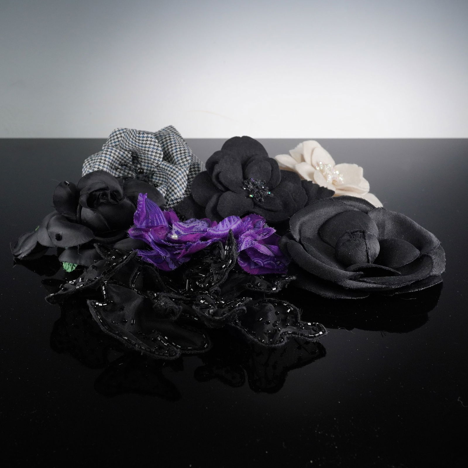 7pc Textile Flower Brooches/Pins: A group of seven textile brooches/pins, predominantly styled as stylized floral forms, alongside one abstract ruffled design. Materials include a grey and white houndstooth woven fabric, black and