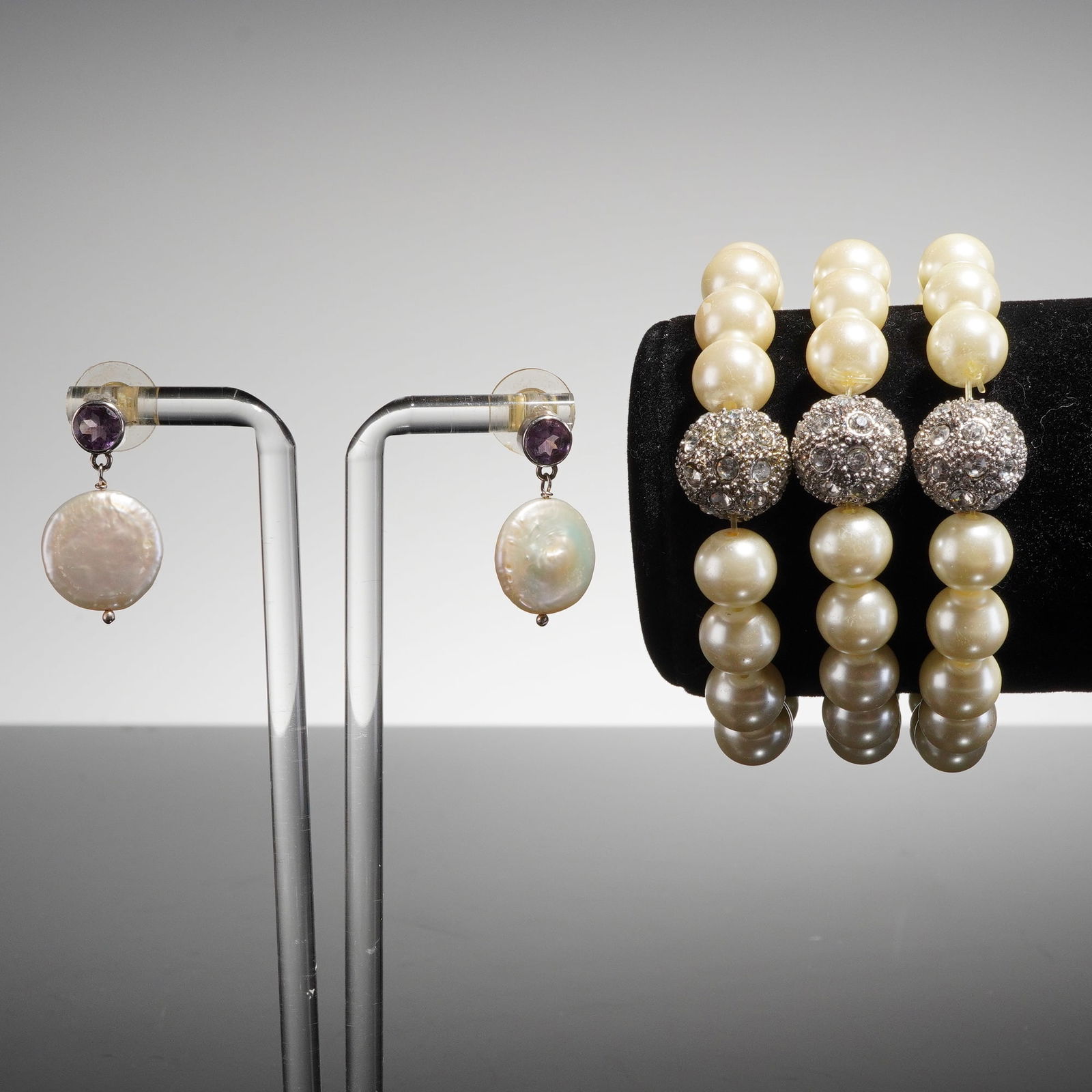 4pc Pearl and Rhinestone Costume Jewelry: A collection of contemporary costume jewelry, consisting of three stretch bracelets and one pair of drop earrings. The three stretch bracelets are composed primarily of large, spherical, creamy white