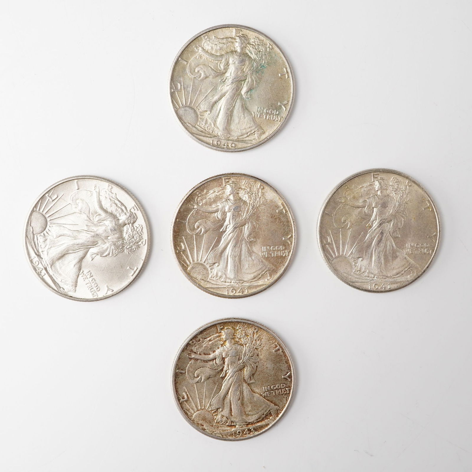 5pc 1940-1943 Walking Liberty Half Dollar Coins: Includes a 1940, 3 1943, and a 1943; all composed of .900 fine silver. The obverse of each coin displays Liberty striding toward the dawn draped in the national ensign with the date below and LIBERTY
