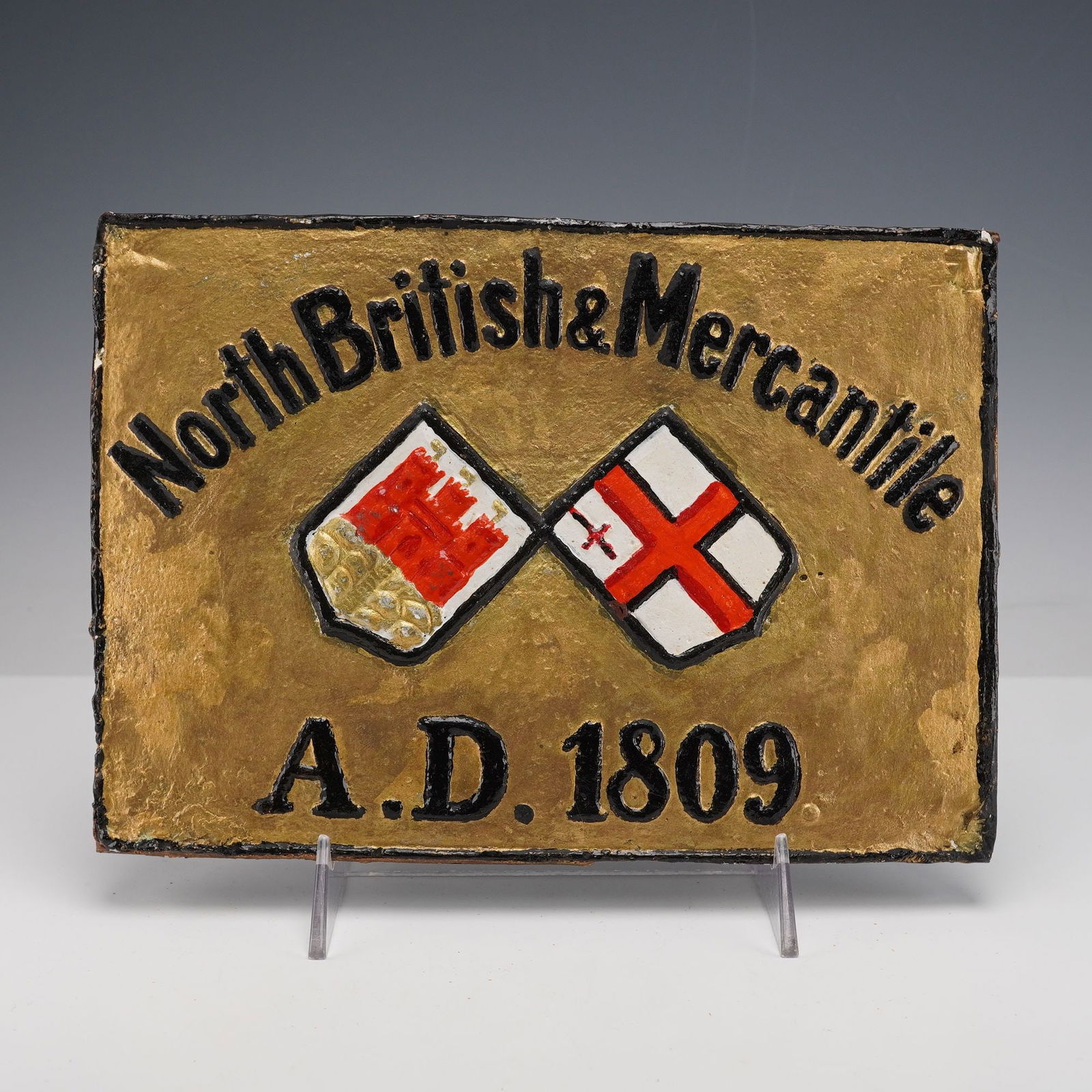 North British Insurance Co by E. V. Jackson Reproduction Fire Mark Plaque: A molded and painted reproduction fire mark plaque for the North British Insurance Company, created by E V Jackson in 1959 and cast from an original. The rectangular plaque features a gilt ground