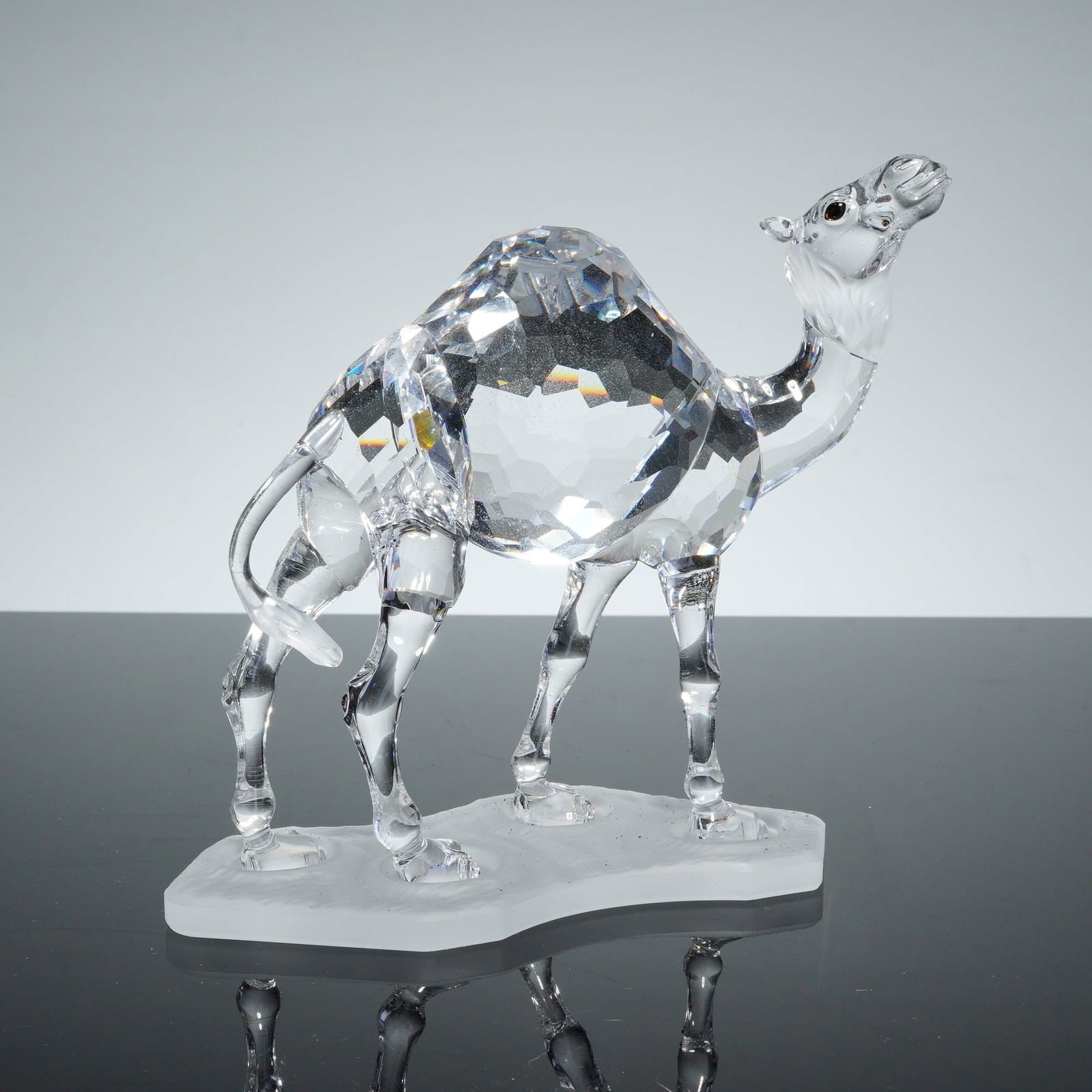 Swarovski Crystal Figurine, Camel: This Swarovski crystal figurine depicts a camel from the African Wildlife series. The piece is constructed from faceted lead crystal, featuring a body and single hump with geometric facets designed fo