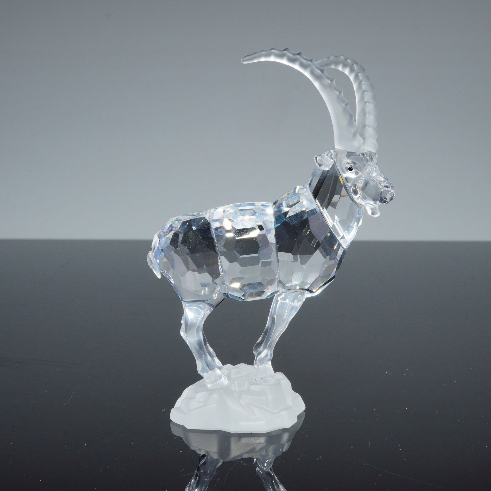 Swarovski Crystal Figurine, Ibex: A Swarovski crystal figurine of an ibex, model number 275439, from the Endangered Species collection. The piece is constructed with a faceted clear crystal body and head, while the elongated horns and
