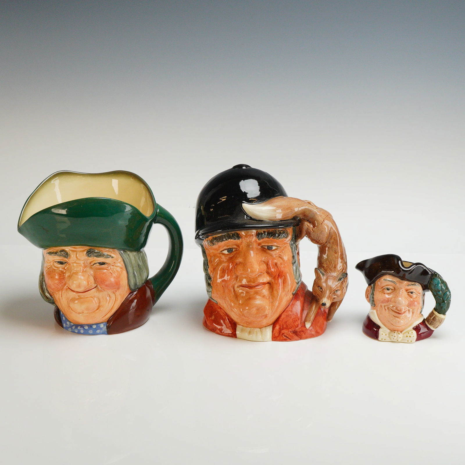 3pc Royal Doulton Character Jugs, Gone Away, Mine Host, and Toby Philpots: A trio of Royal Doulton glazed ceramic character jugs featuring hand-painted polychrome finishes. The collection includes a large Gone Away D6531 jug, depicting a huntsman with a fox-form handle and t