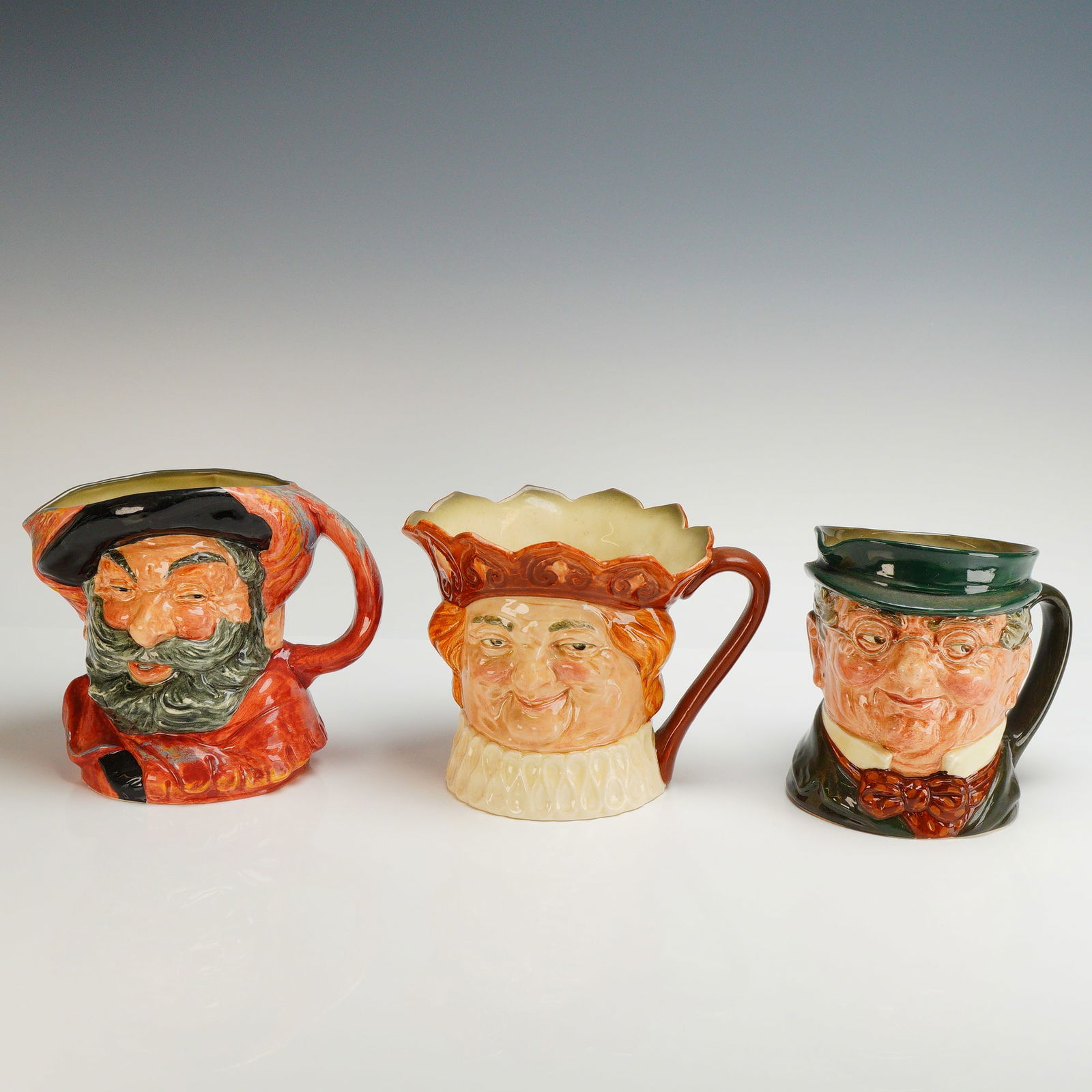 3pc Royal Doulton Large Character Jugs: Three Royal Doulton glazed ceramic large character jugs, mid-20th century, depicting historical and literary figures. The collection includes Falstaff, portrayed with a full gray beard and black hat o