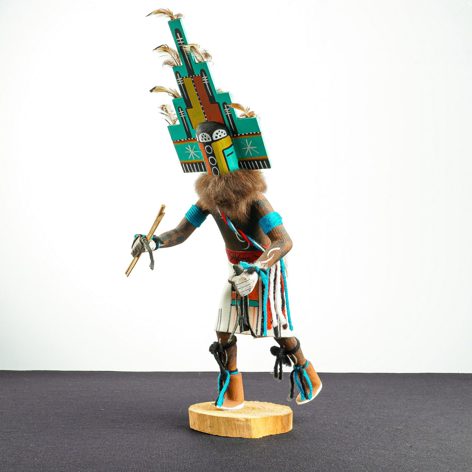 Native American Hopi Hemis Kachina Doll: A hand-carved and painted wooden Hemis Kachina doll featuring a shirtless torso and wearing white pants with a traditional kilt overlay. The figure is depicted holding sticks and a leather rope while