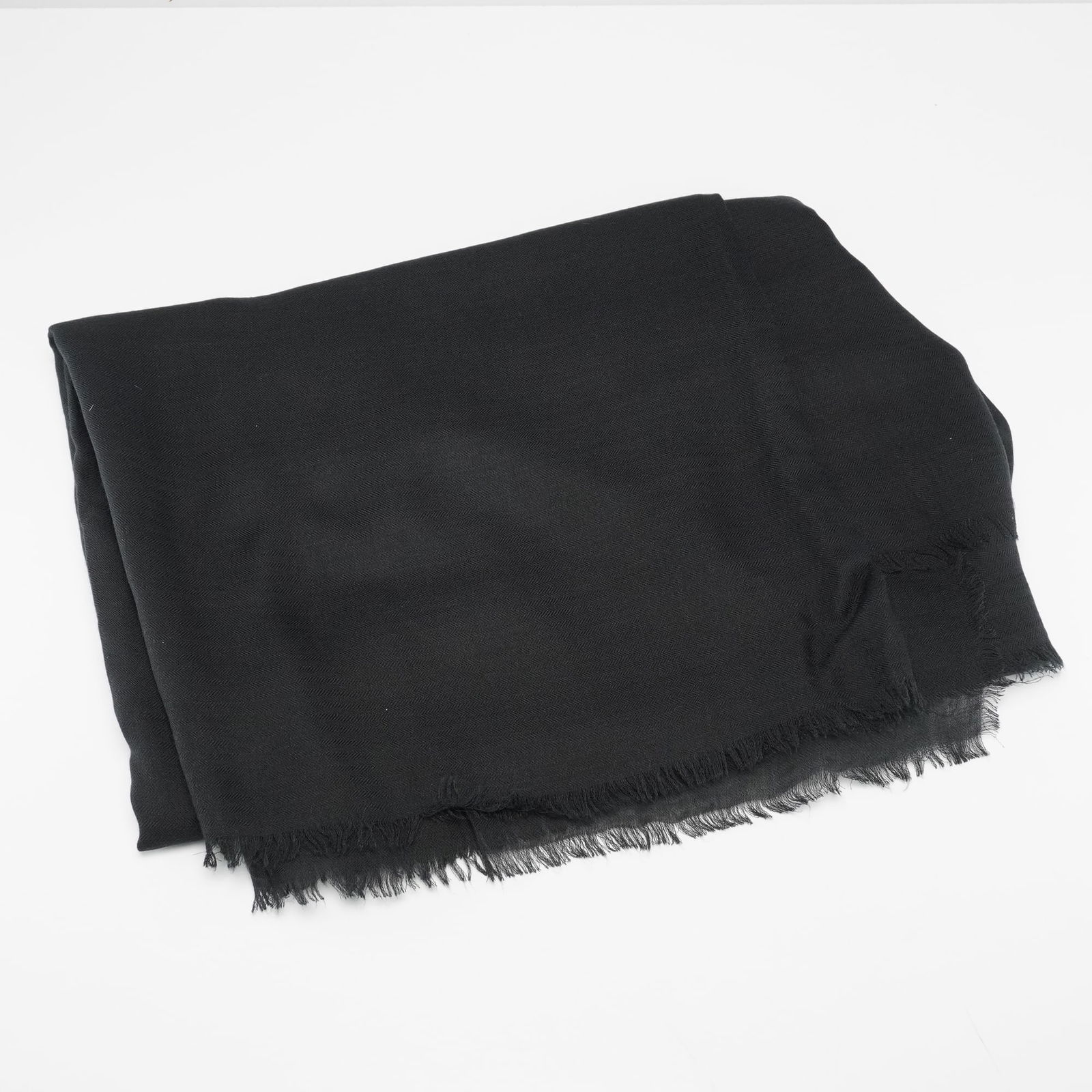 Emporio Armani Black Modal and Cashmere Herringbone Scarf: An Emporio Armani black scarf, crafted in Italy from a blend of 90% Modal and 10% Cashmere. This accessory features a subtle herringbone weave pattern and fringed edges. The attached label confirms