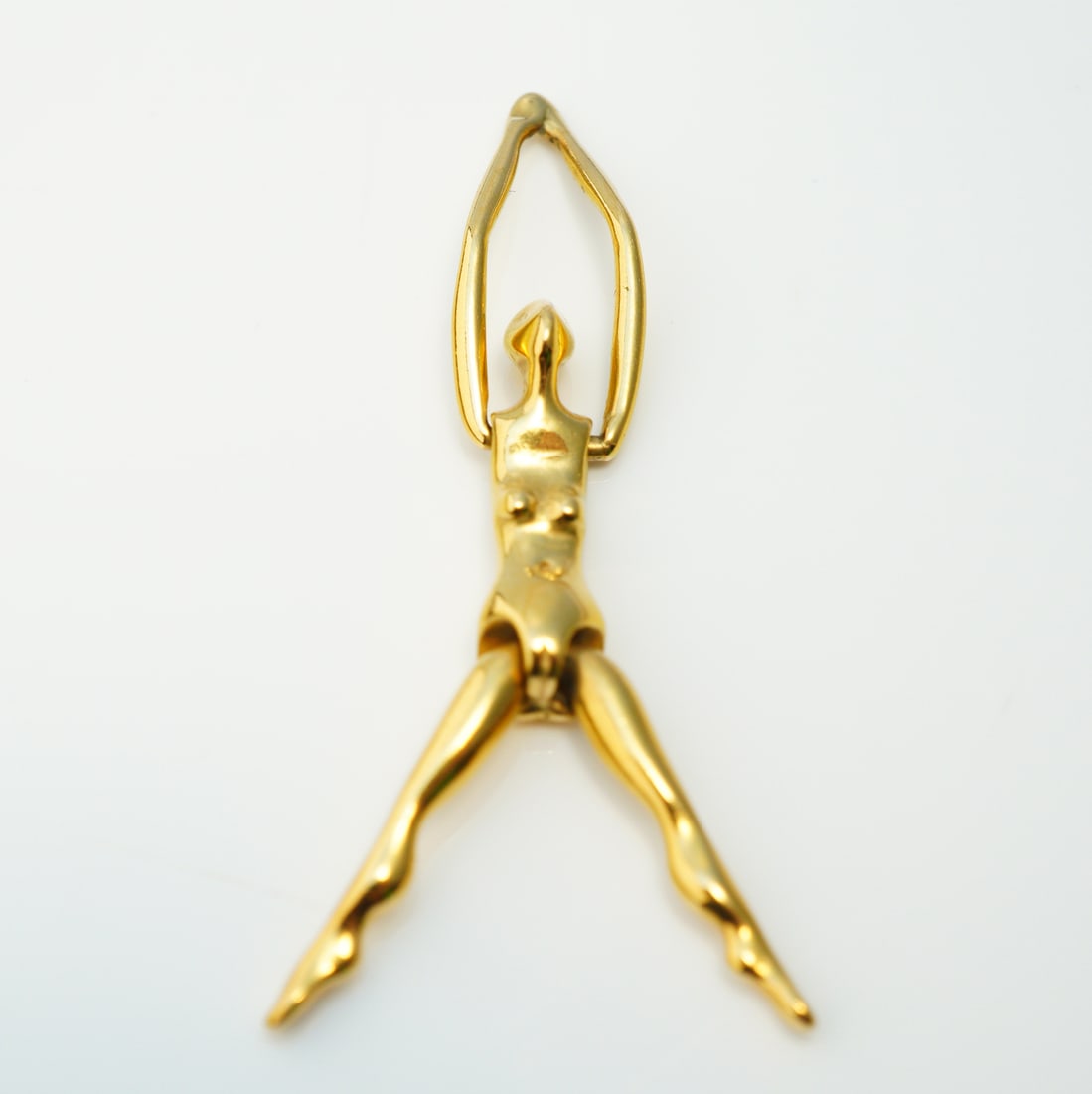 Charles Jourdan Paris Articulated Gold-Plated Figural Pendant: An articulated gold-plated pendant by designer Charles Jourdan. The single item is constructed from polished gold-plated metal and depicts a highly stylized, nude female figure in a modernist figurati
