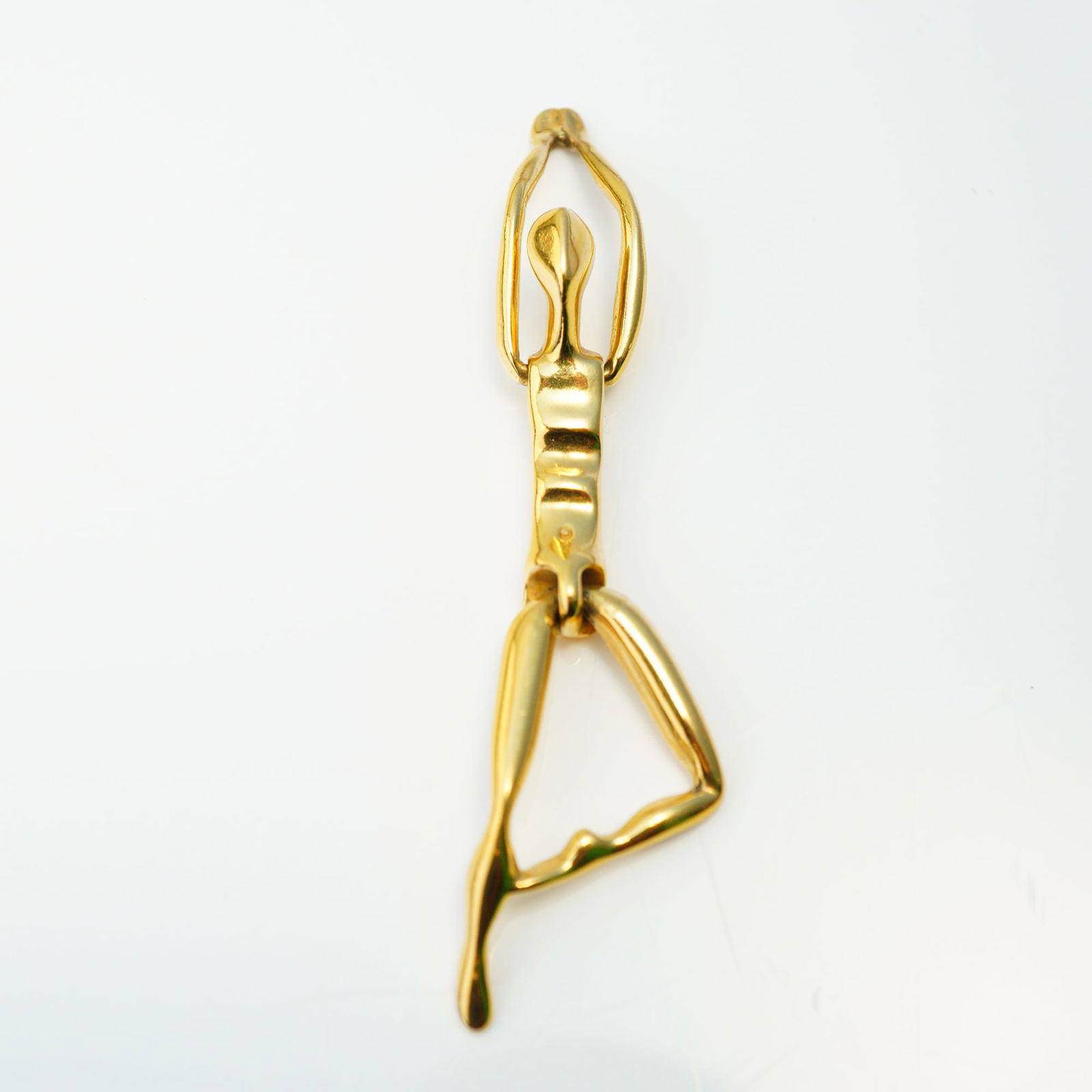 Charles Jourdan Paris Articulated Gold-Plated Figurine Pendant: A single articulated figurine pendant by Charles Jourdan, crafted from highly polished gold-plated metal, featuring a minimalist, abstracted human form. The figure is articulated at the waist and hips