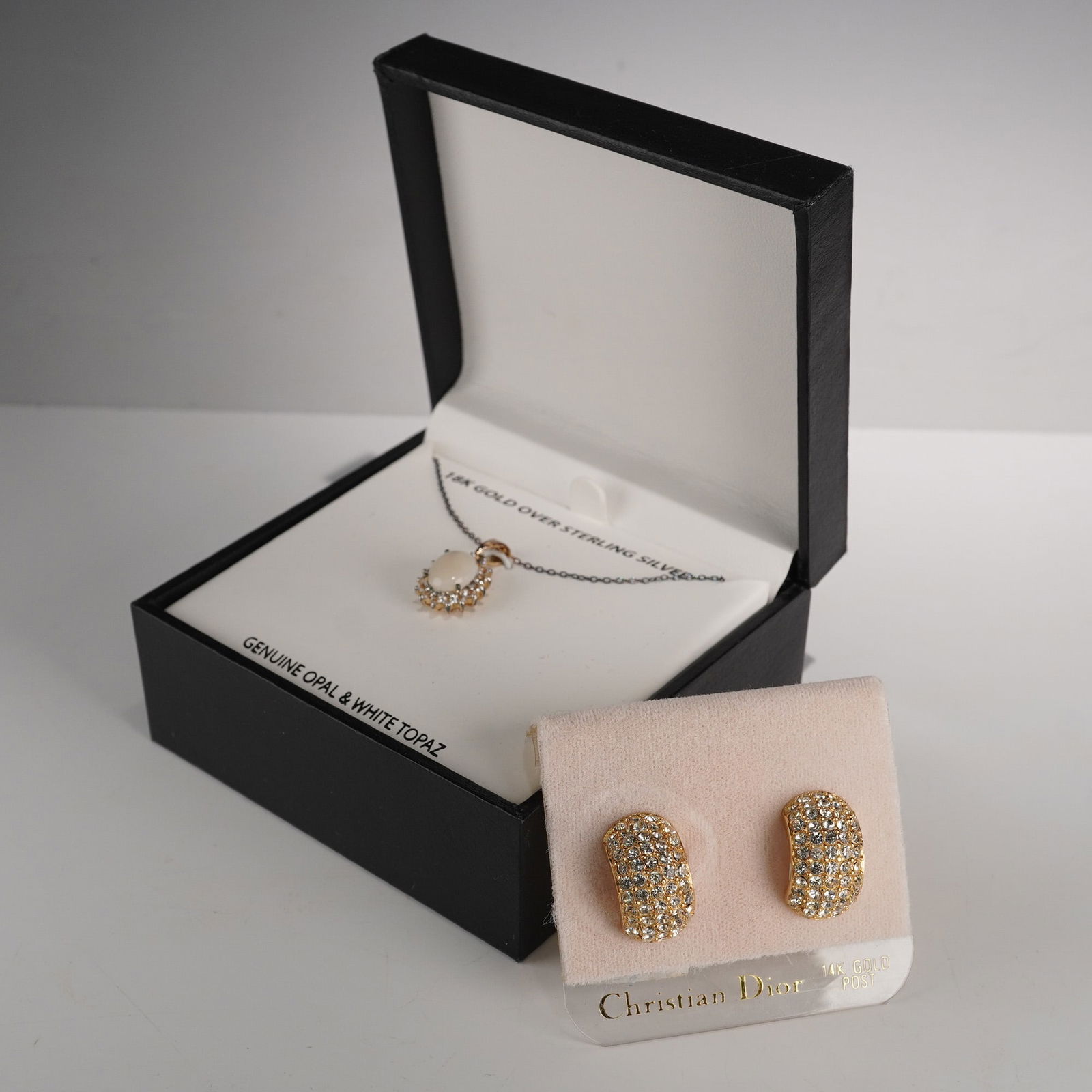 18K Gold Plated Sterling Silver Opal Necklace & Christian Dior Earrings: A pair of Christian Dior gold-tone, pave-set dome-shaped stud earrings, adorned with clear rhinestones/crystals. The earrings are presented on a pink card marked "Christian Dior" and "14K GOLD POST,"