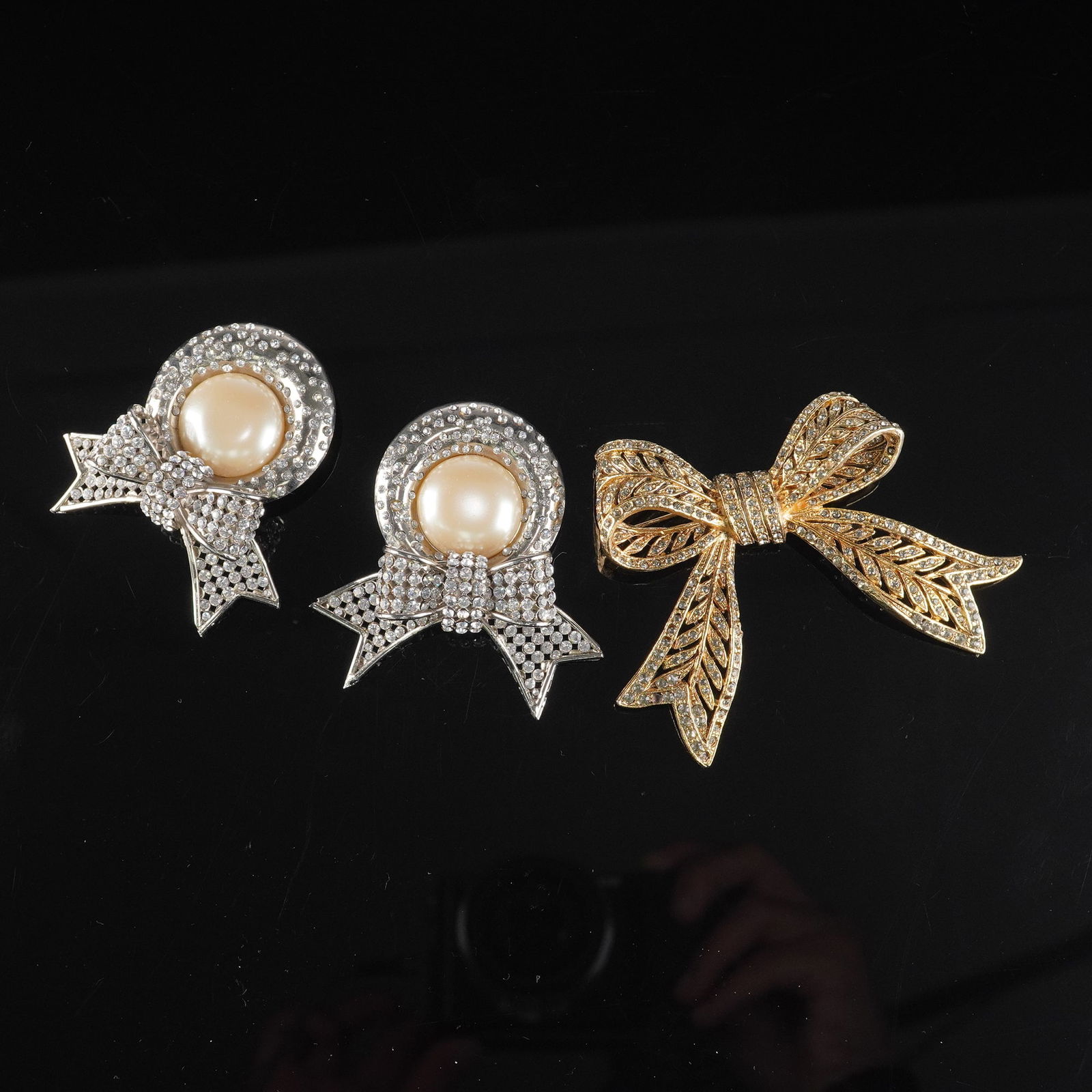 3pc Pair of Valentino Silver-Toned Faux Pearl and Rhinestone Brooches: This lot includes a pair of Valentino silver-toned costume brooches, each featuring a central faux pearl cabochon encircled by small, clear faceted stones, with a stylized ribbon element below, also s