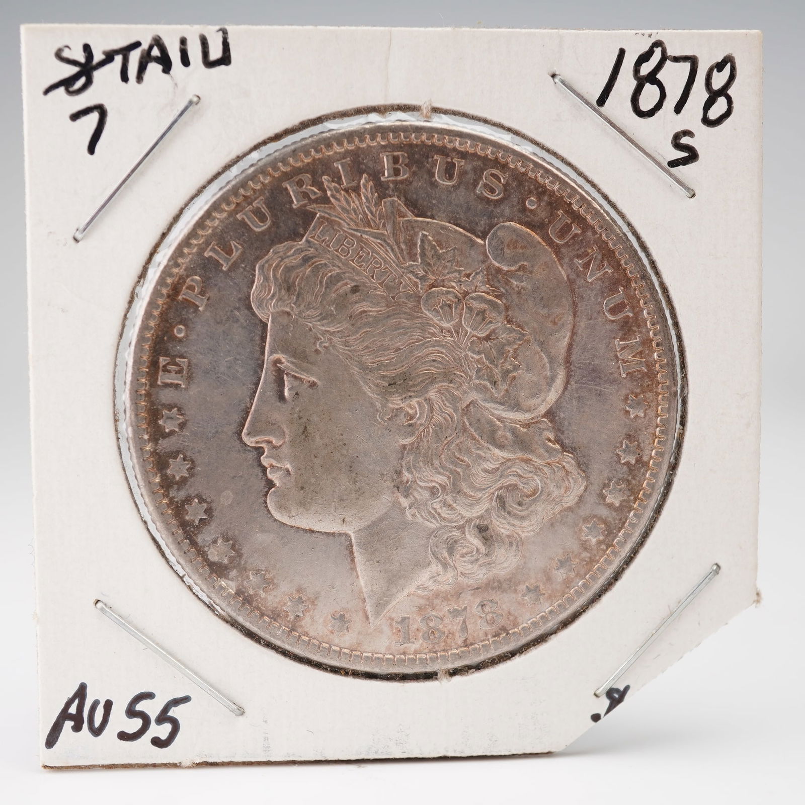 1878-S Morgan Silver Dollar: An 1878-S Morgan Silver Dollar from the San Francisco Mint, distinguished as the 7 Tail Feathers variety from the first year of issue. The obverse features the classic portrait of Liberty adorned