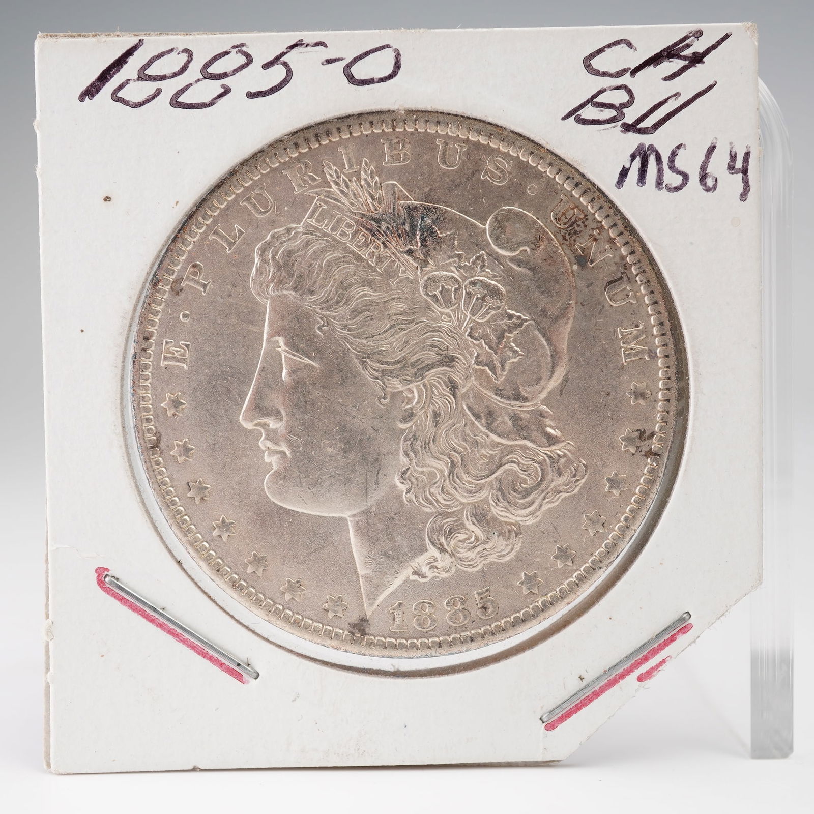 1885-O Morgan Silver Dollar: An 1885-O Morgan Silver Dollar struck at the New Orleans Mint. The obverse features the iconic portrait of Liberty by George T. Morgan, crowned with a Phrygian cap and encircled by E PLURIBUS UNUM and